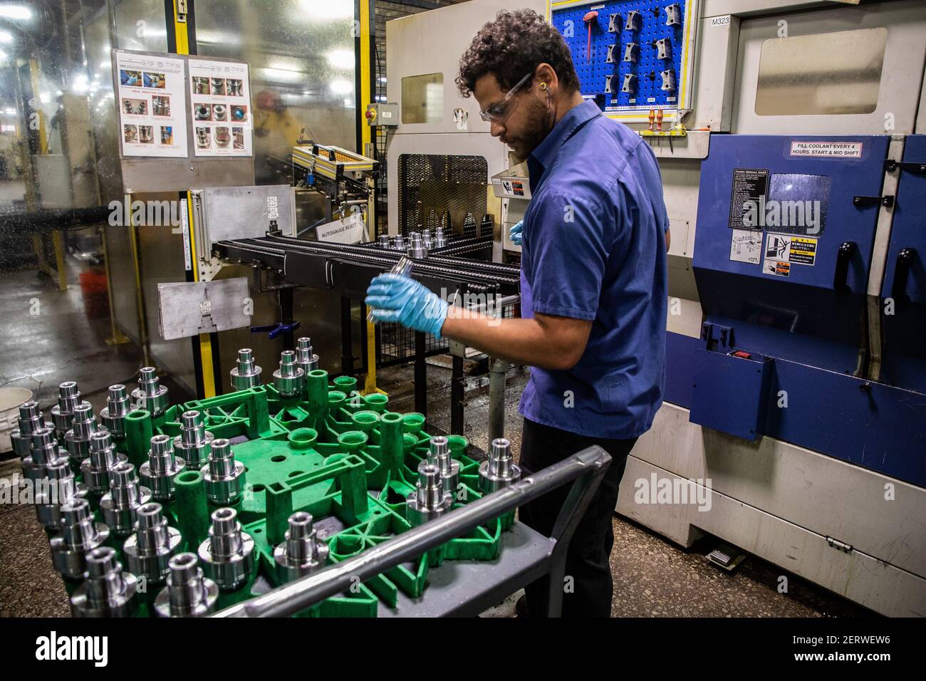 Machine operator Matt Mollema inspects parts before feeding them to robots  for sorting at Kay Manufacturing, an automotive parts company in Calumet  City on Wednesday, Sept. 12, 2018. (Photo by Zbigniew Bzdak/Chicago