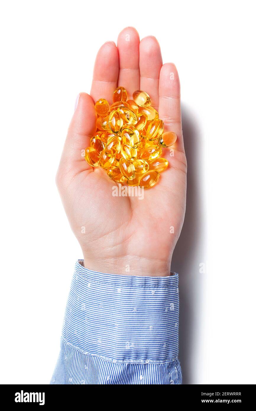 Hand holds omega-3 capsules isolated on white background. Fish oil tablets on the palm Stock Photo