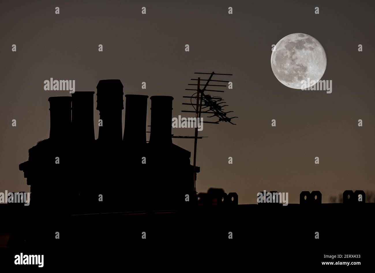 Full Moon rising over a London Household Chimney stack Stock Photo