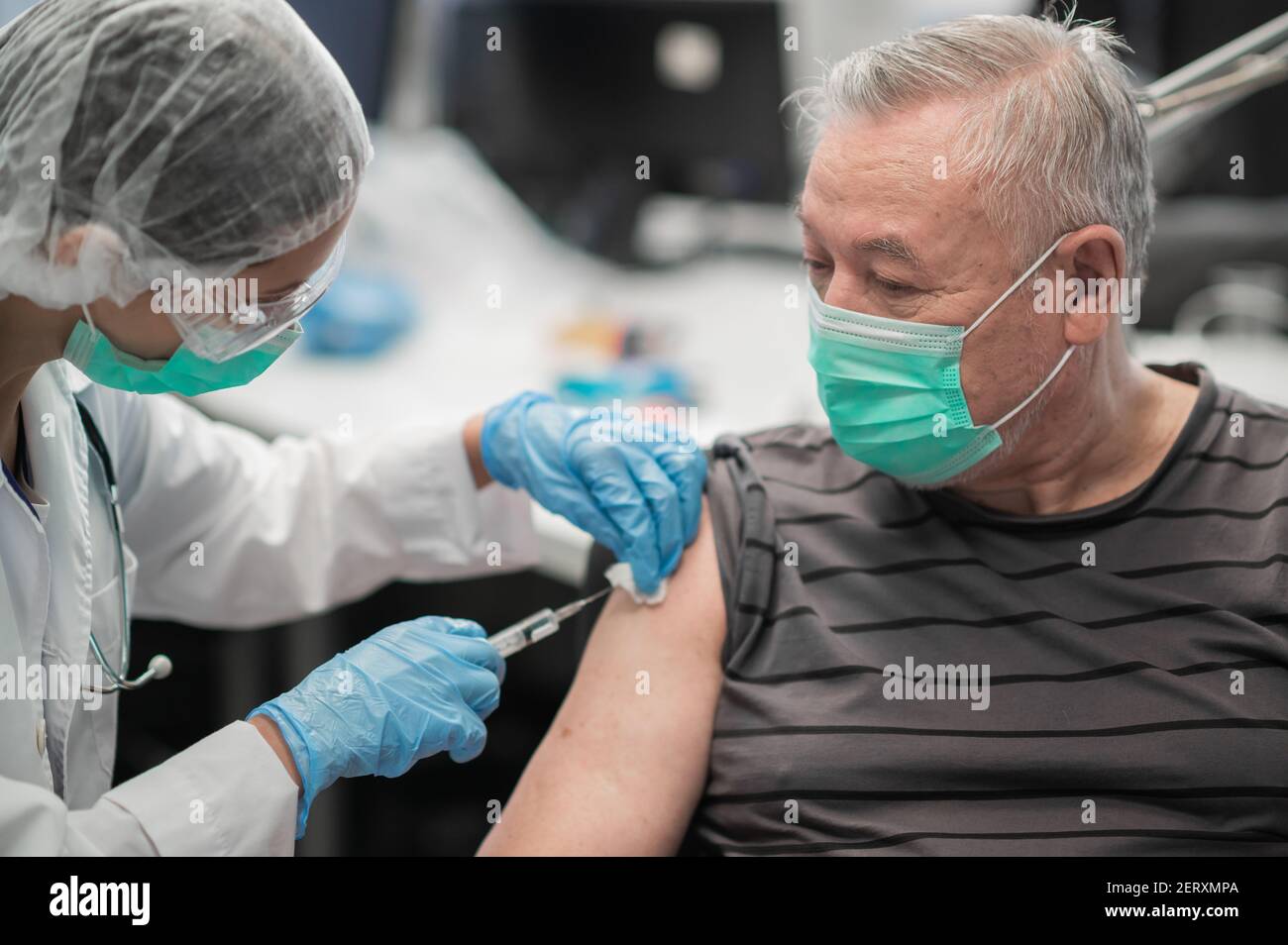 An experienced female doctor gives an injection in the shoulder with ...