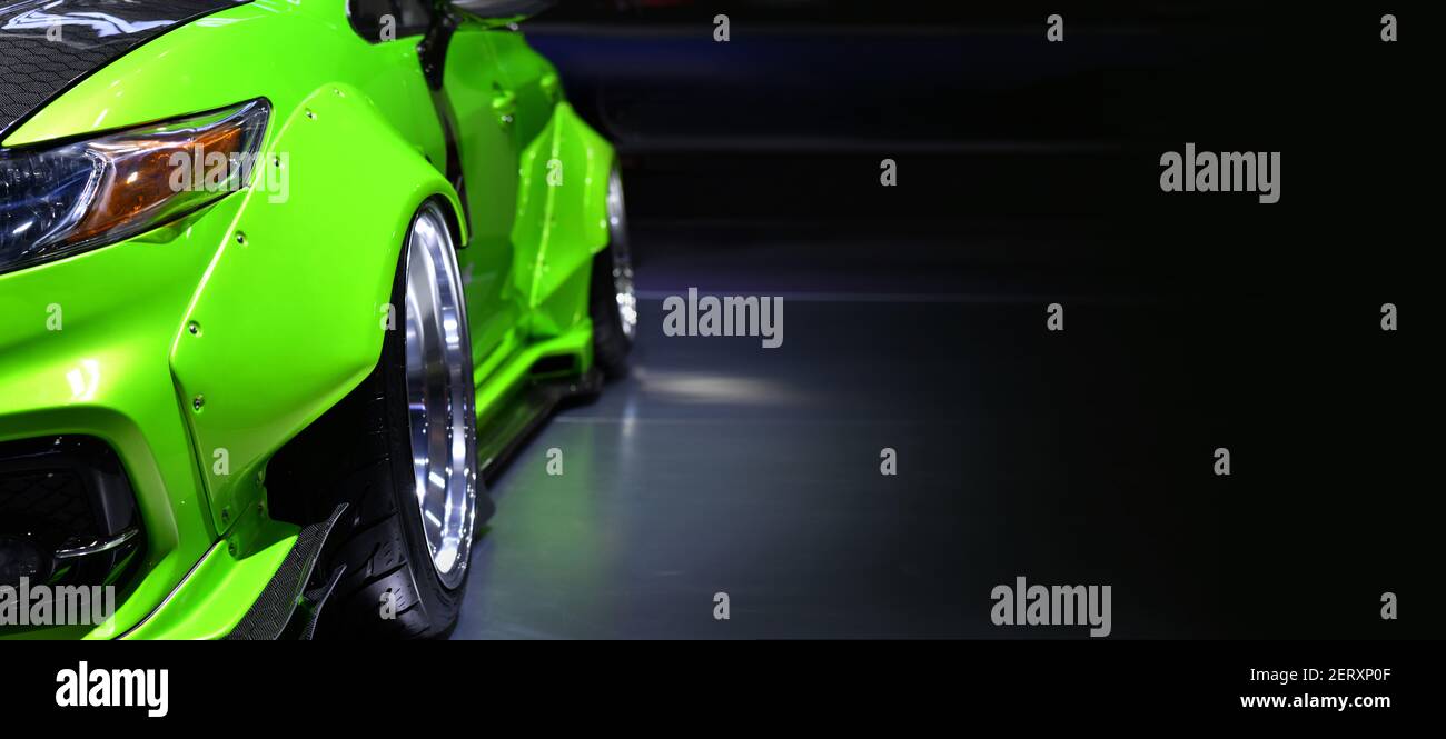 Front headlights of green modify car on black background, copy space Stock Photo