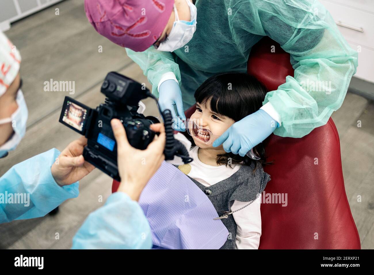 Stock photo of female dentist wearing face mask taking picture of a young patient Stock Photo