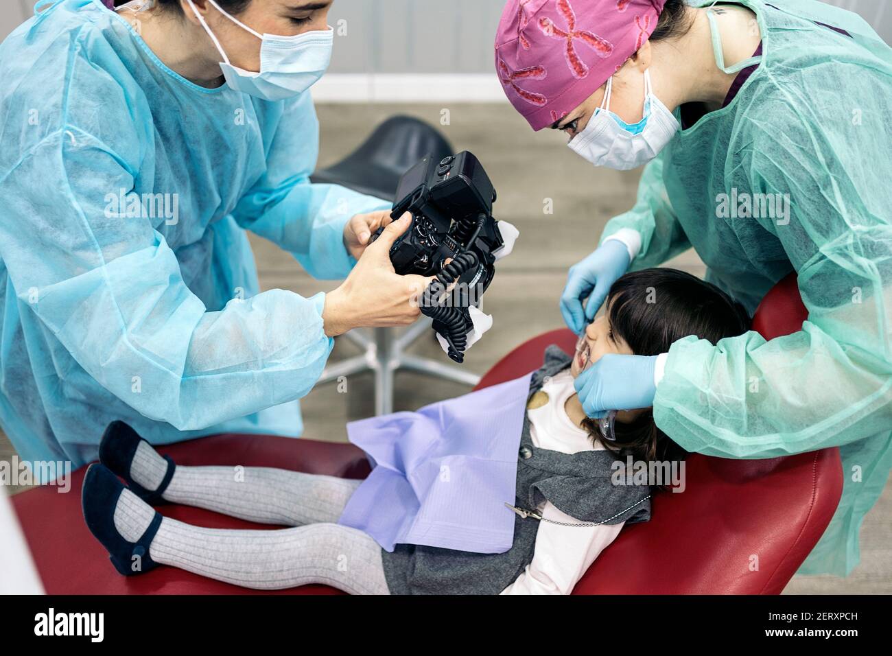 Stock photo of female dentist wearing face mask taking picture of a