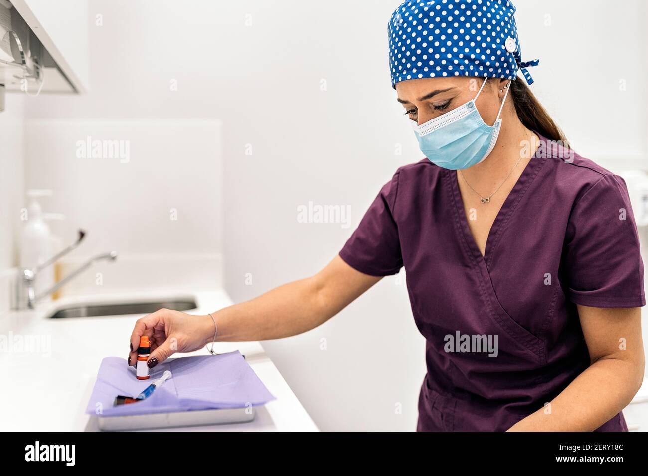 Stock photo of woman wearing face mask and hair net working in modern