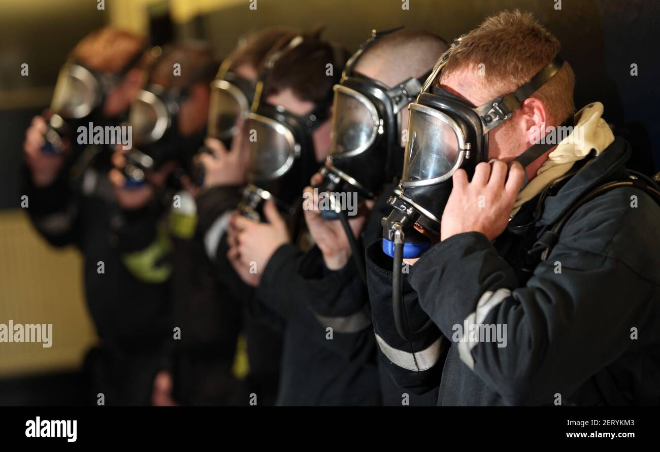 Fire trainees trying out breathing apparatus masks Stock Photo