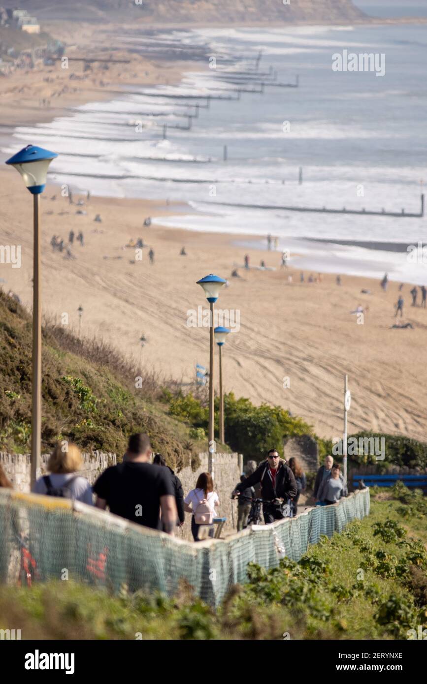 Pedestrians walk up and own the zig zag leading to the beach at Fisherman’s Walk, Southbourne, Bournemouth on a beautifully sunny February day during Stock Photo