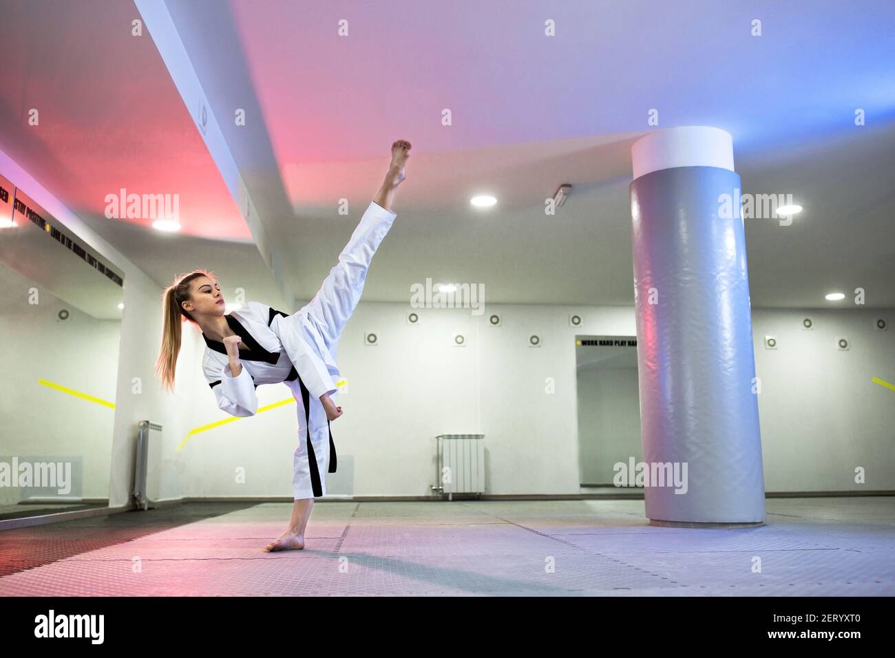Cute girl with dyed blonde hair practicing martial art of taekwondo ...