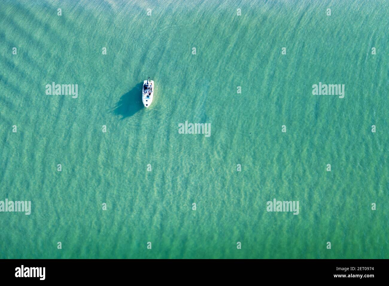 White yacht and turquoise water waves from top view. Travel summer vacations seascape background from drone Stock Photo