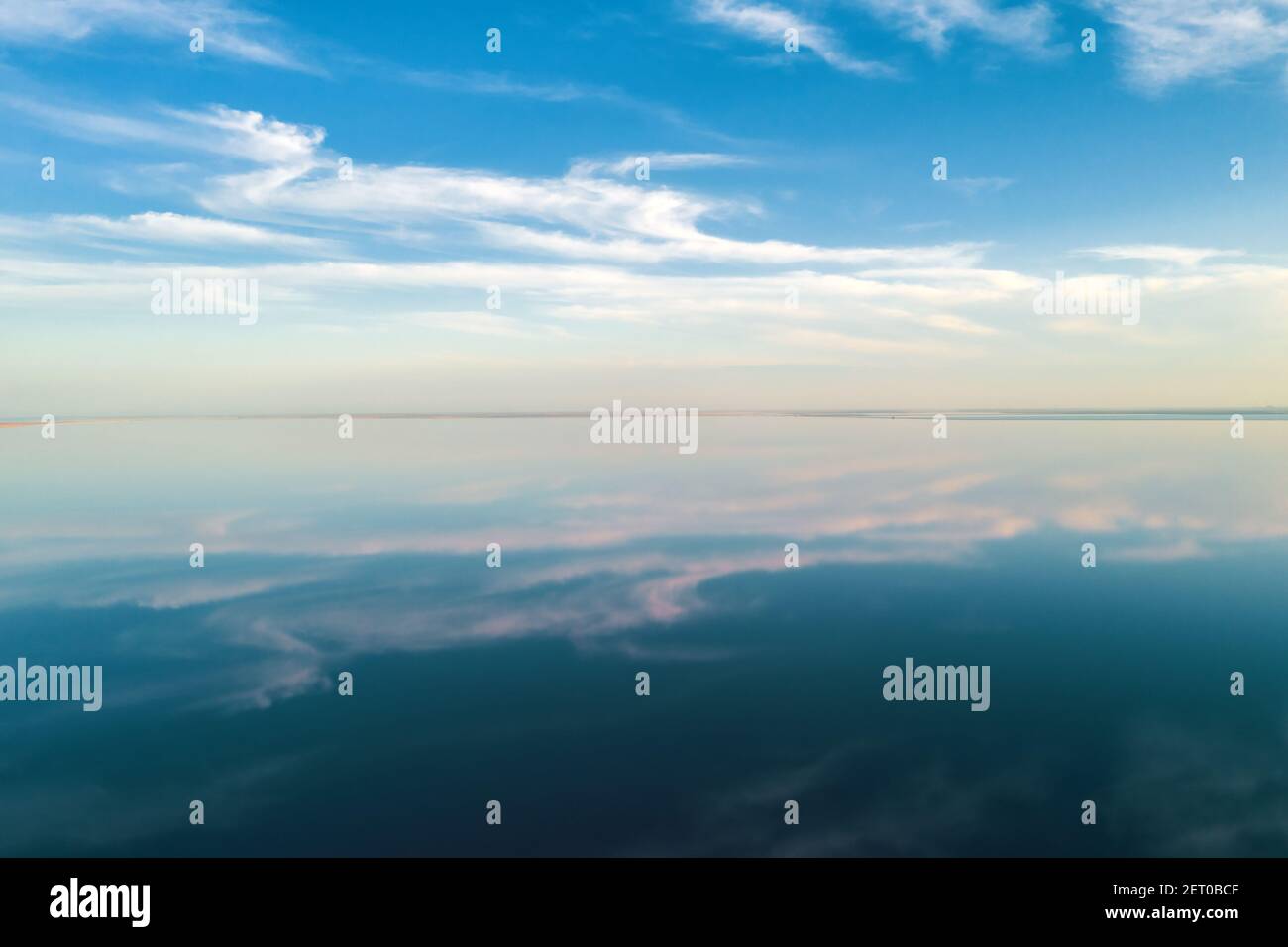 Salt lake water under blue sky with fluffy clouds in summer day. Creative color concept Stock
