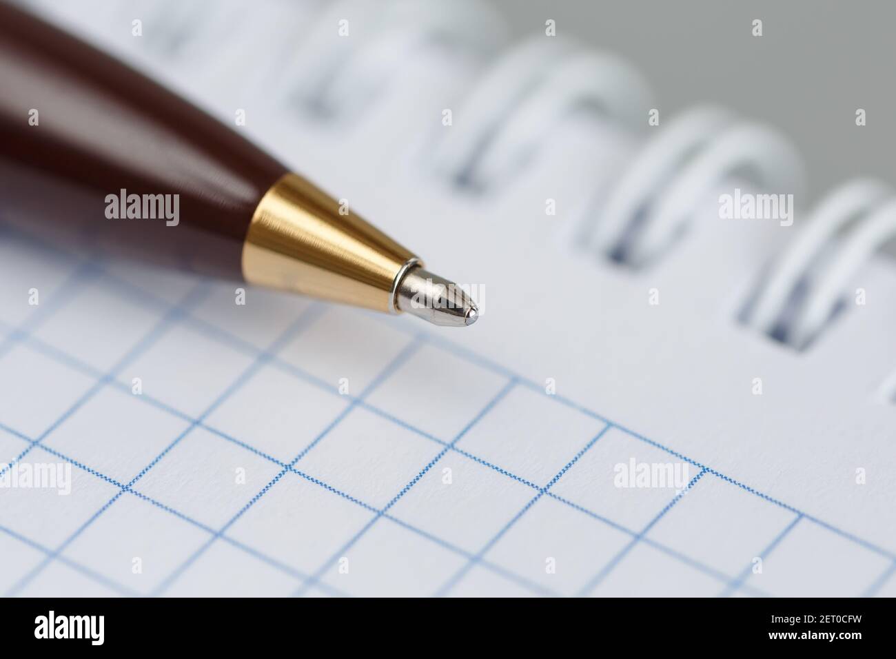 Ballpoint pen closeup on the background of a notepad with a spring