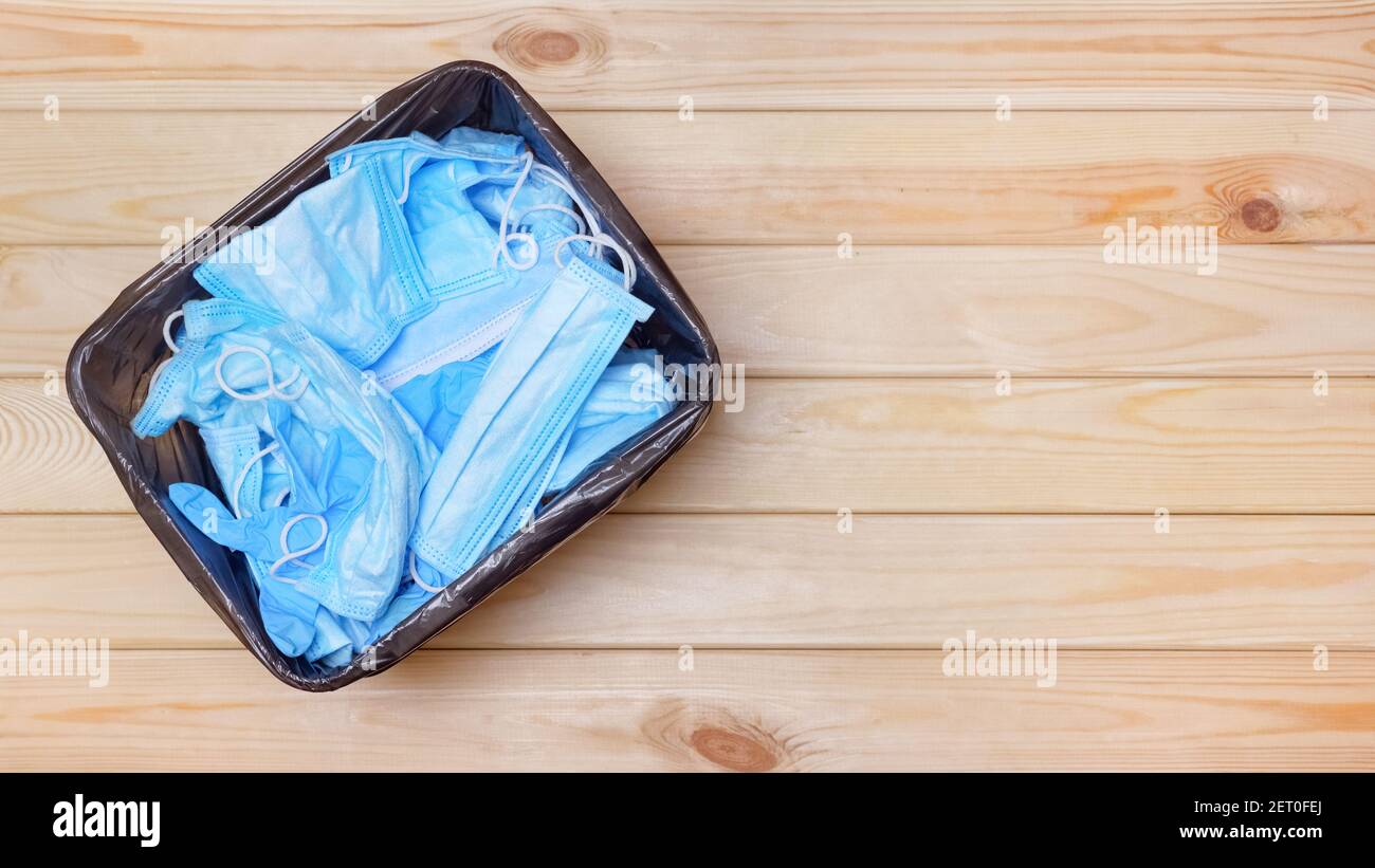 Post covid office bin. Used masks in waste banner bin on floor top view