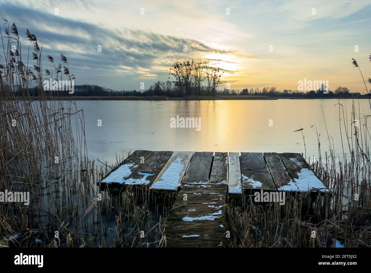 A fishing platform in the reeds and sunset over a calm lake, winter landscape, Stankow, Lubelskie, Poland Stock Photo