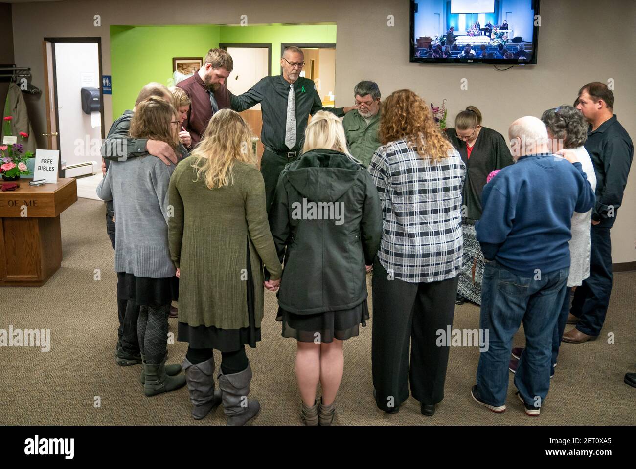 Rev. Jim Woldhuis prays with family members before entering the