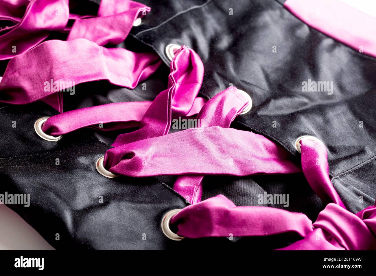 Pink Cord In Fashionable Black Lace Up Dress, macro. Background Stock Photo