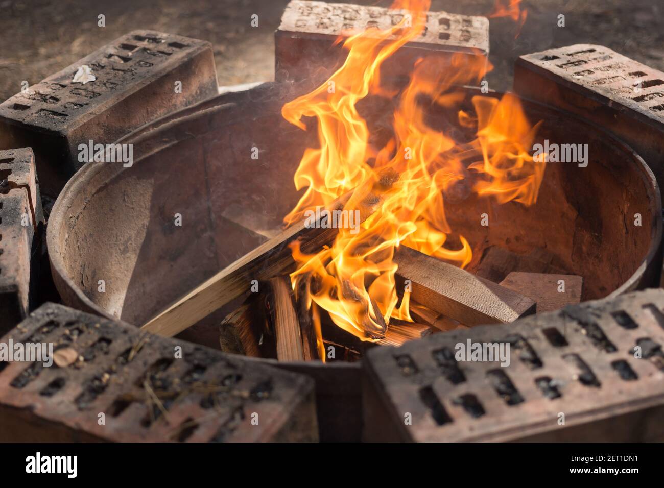 Burning fire on a round brick fireplace. Stock Photo