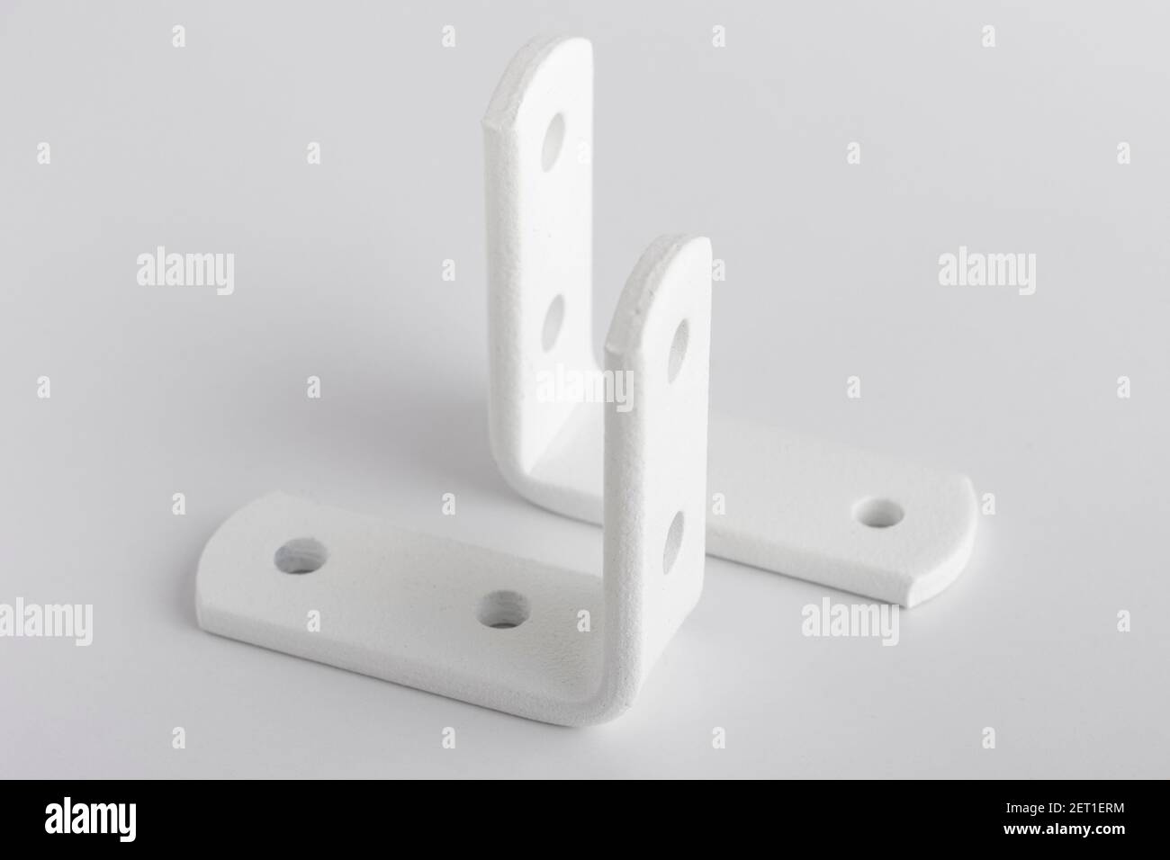 Metal corners for mounting on a white background. corners for fixing cabinets Stock Photo