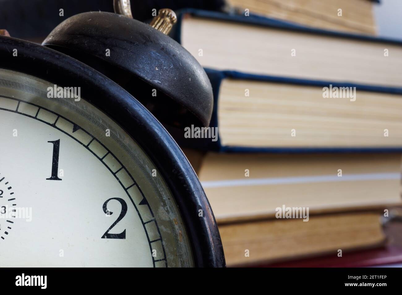 Time to learn concept. Close up of alarm clock and book. Stock Photo