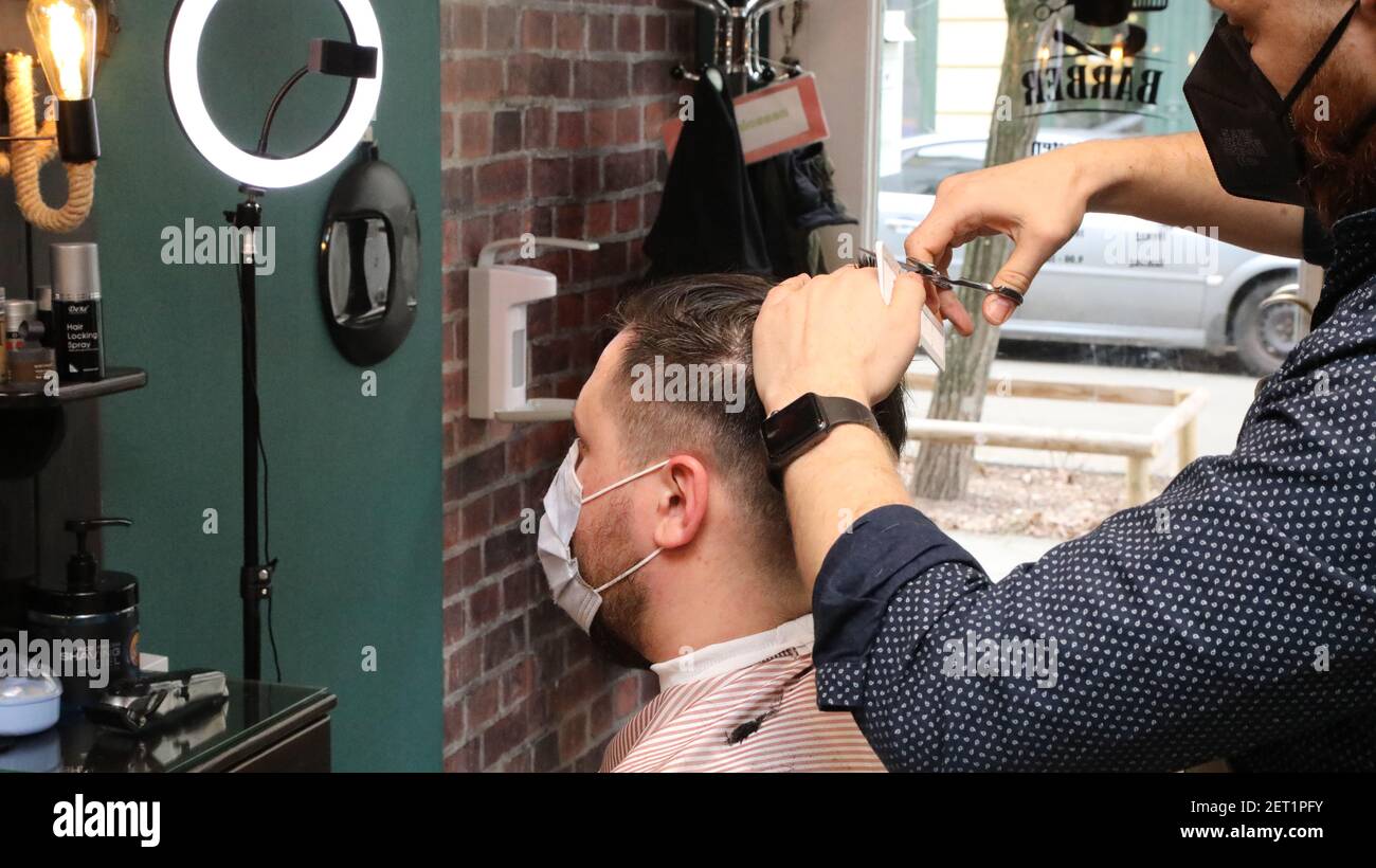 Nach Monaten des Corona Lockdowns dürfen Friseure ab Montag, unter Auflagen, wieder Haare schneiden, hier der Syrer Mohamad Habboush in seinem Barbers Stock Photo