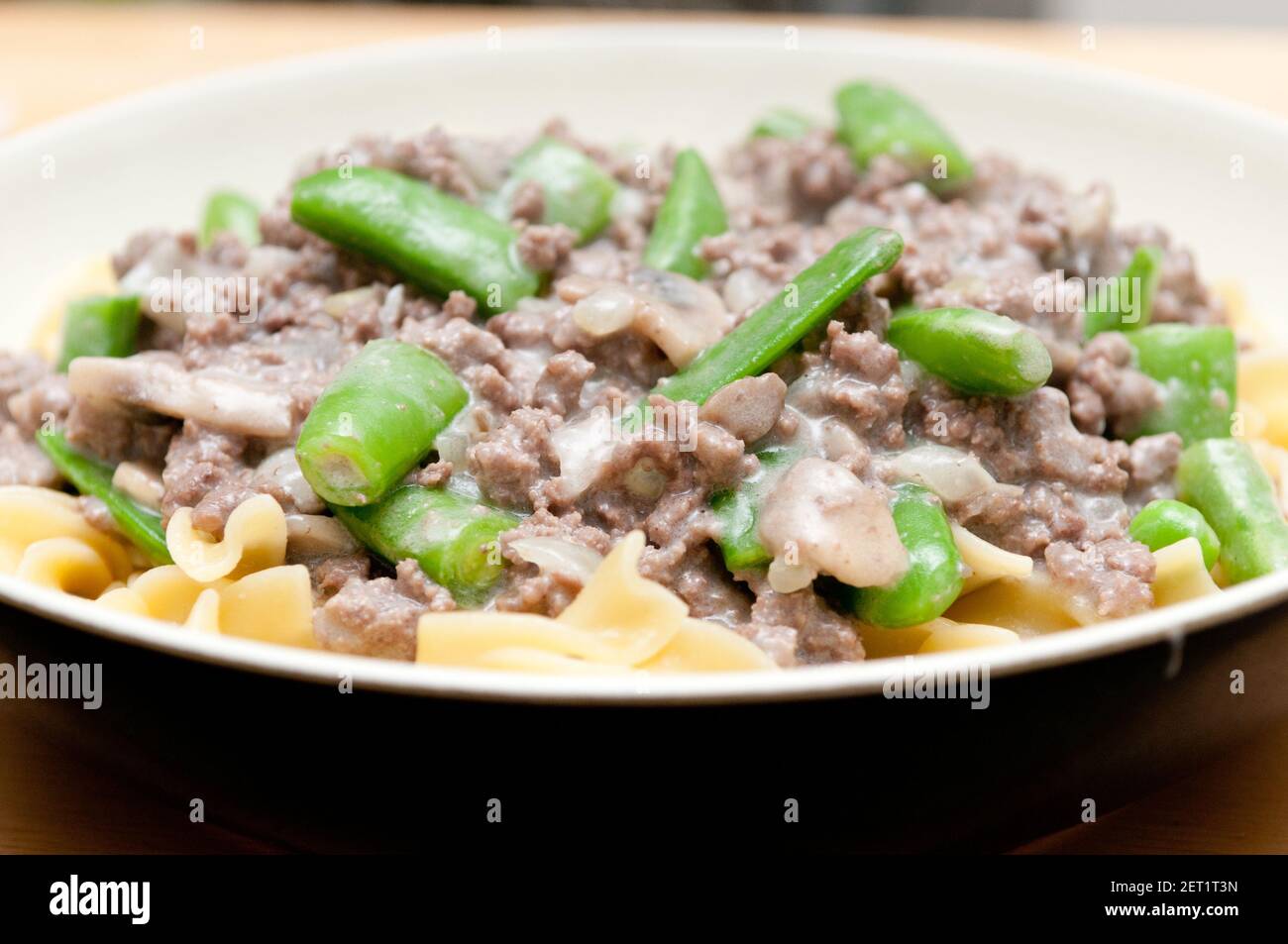 ground beef hamburger stroganoff with chopped snap peas and broad egg noodles in a mushroom