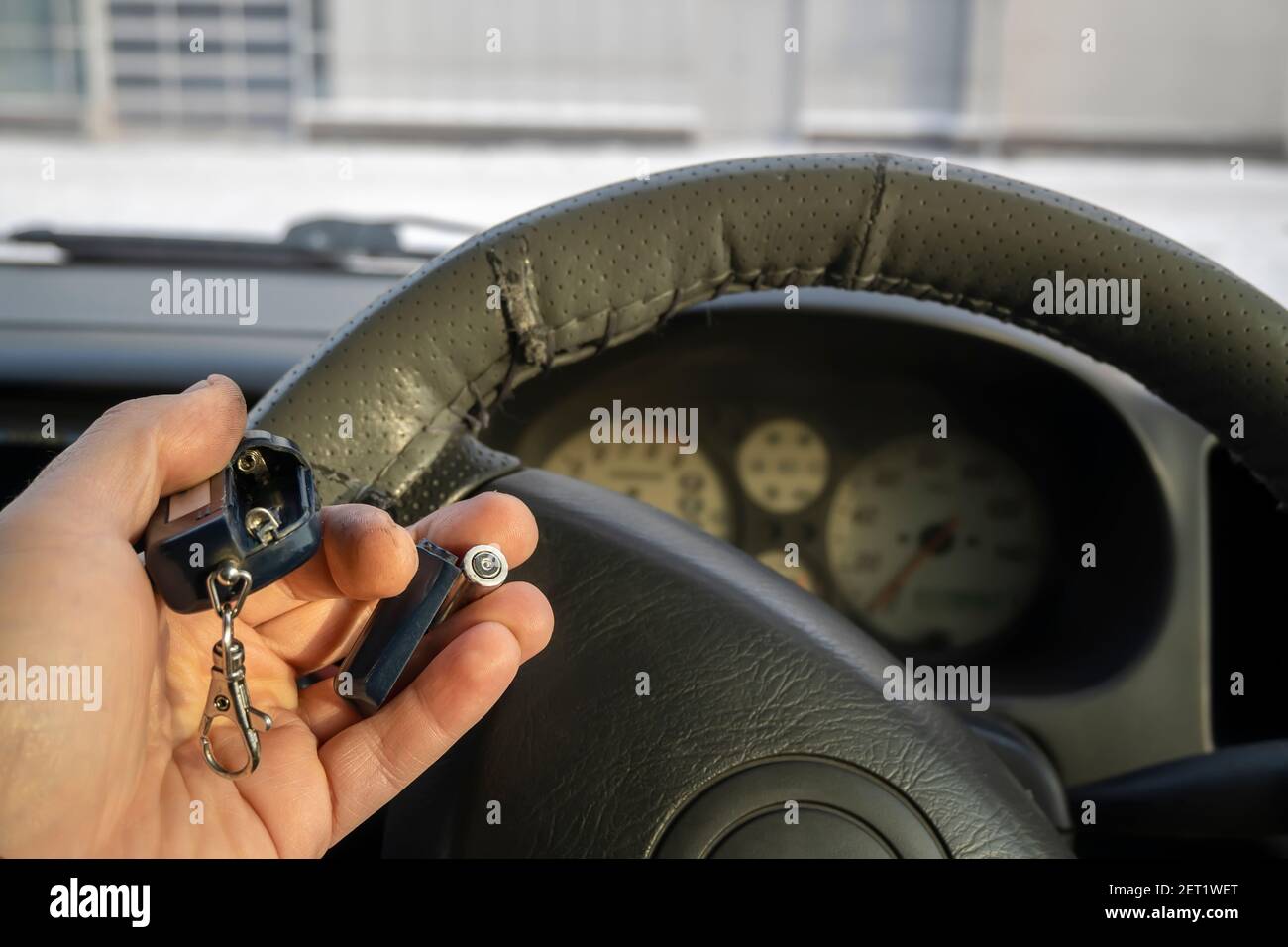 empty, dead battery and car alarm keychain in the car driver's hand