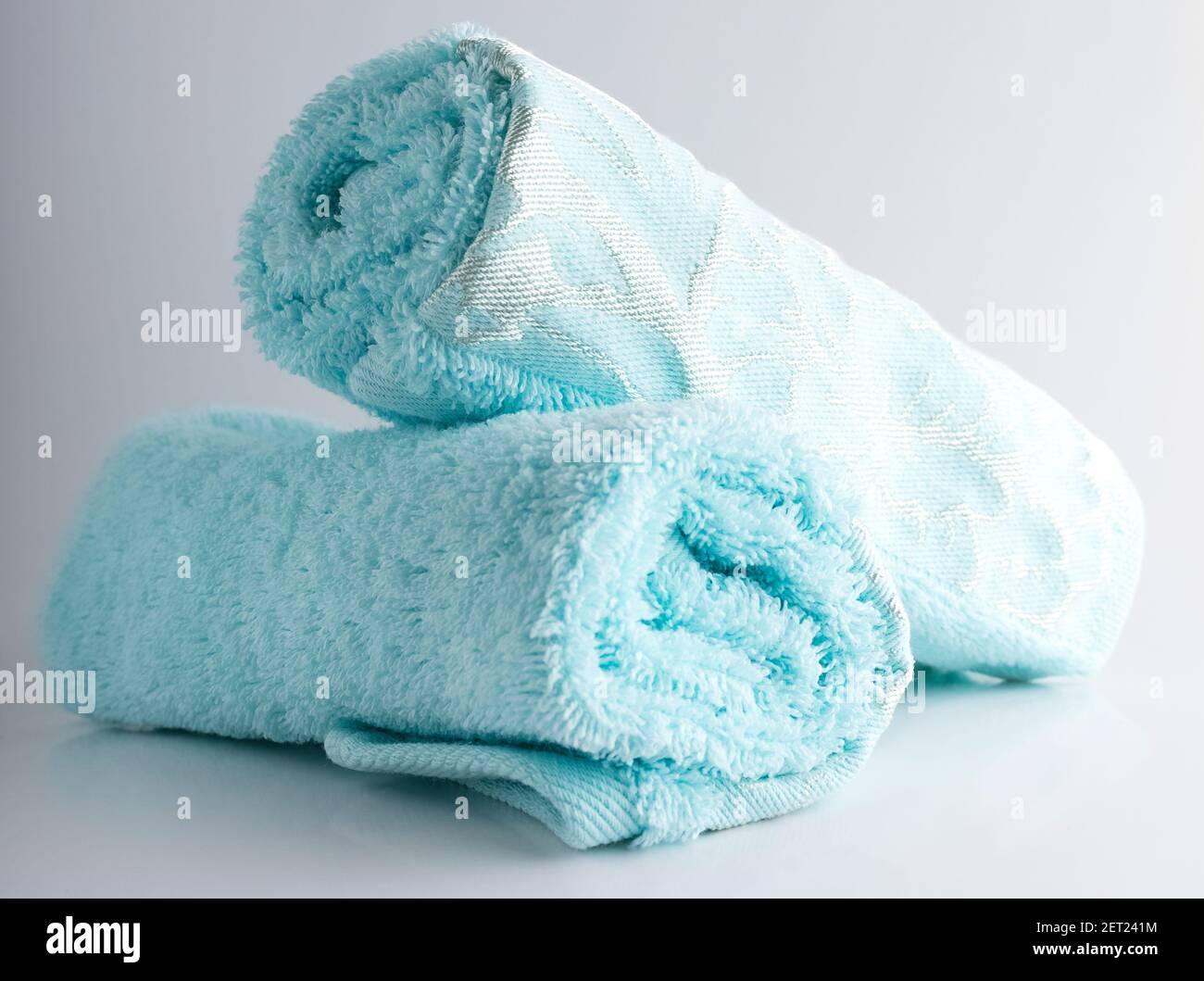 two rolls of blue towels on a white background Stock Photo