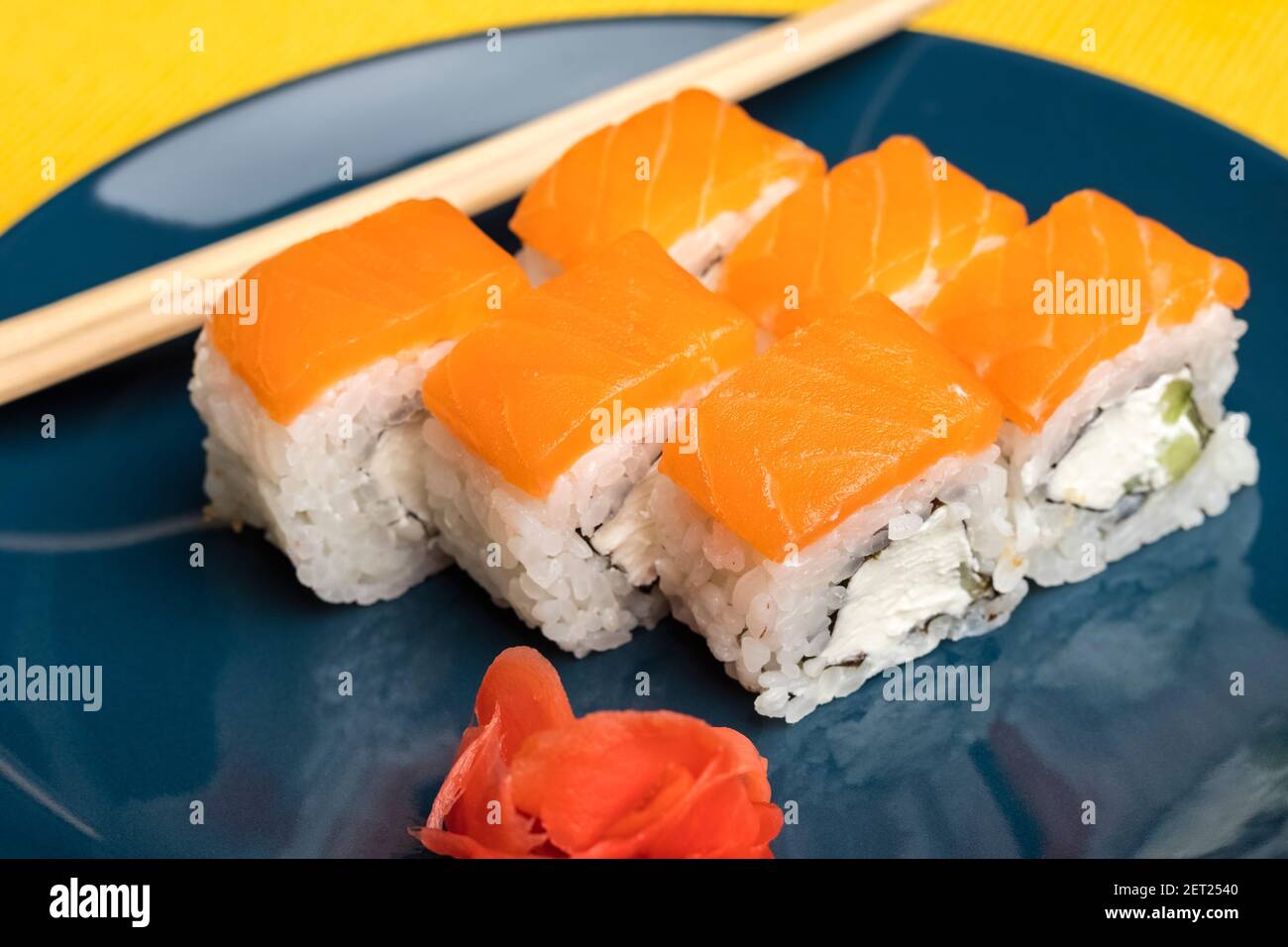 Rolls with pieces of salmon on a blue plate Stock Photo