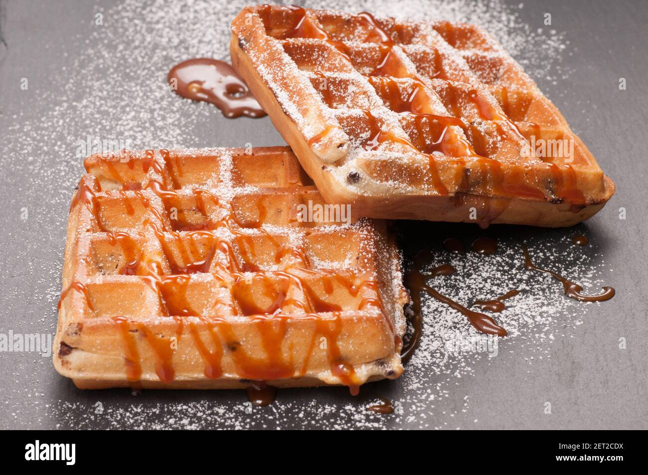 toasted chocolate chip waffles with caramel and powdered sugar Stock