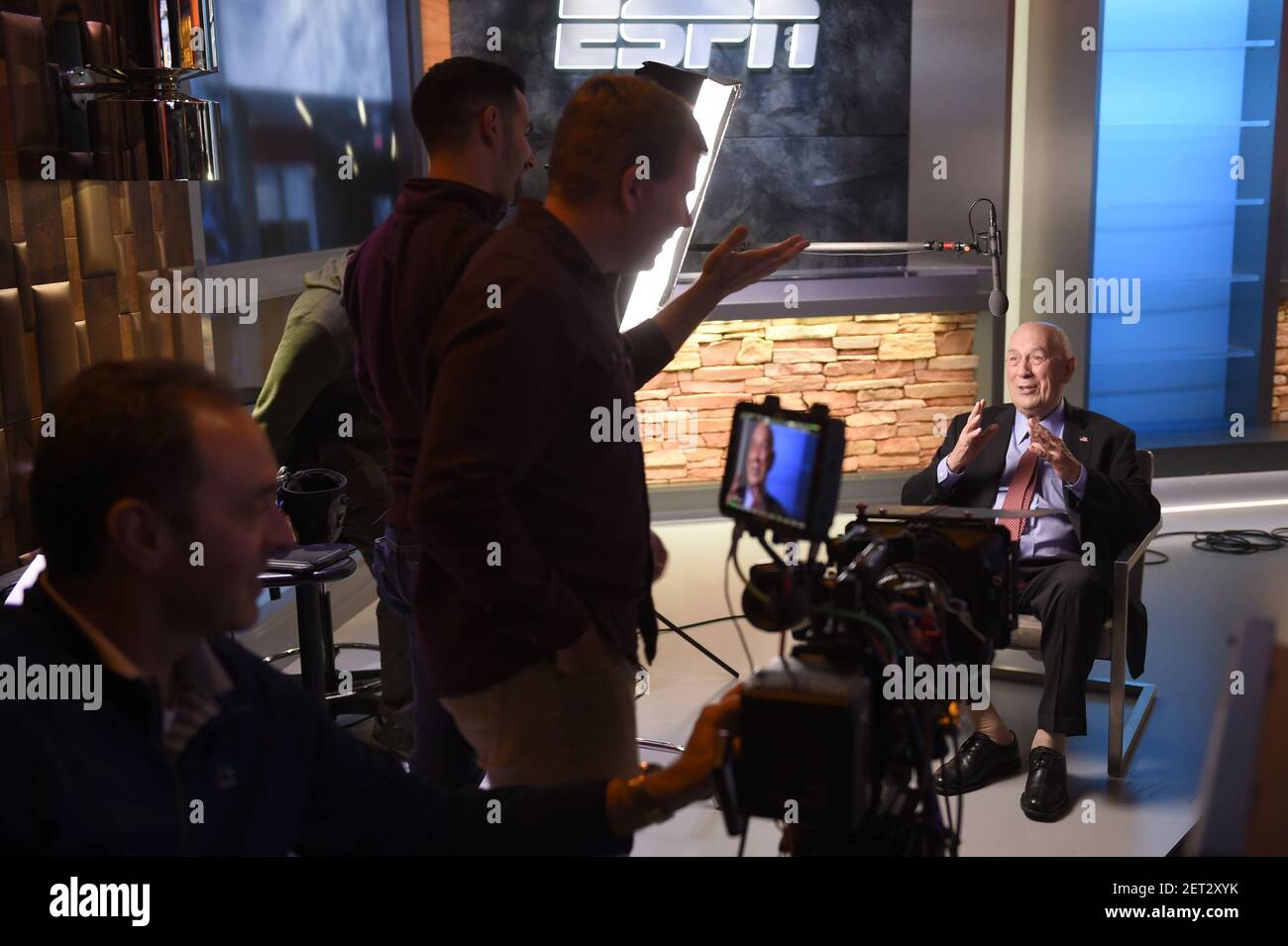 Bill Rasmussen, founder of ESPN, settles in on the set with the crew of
