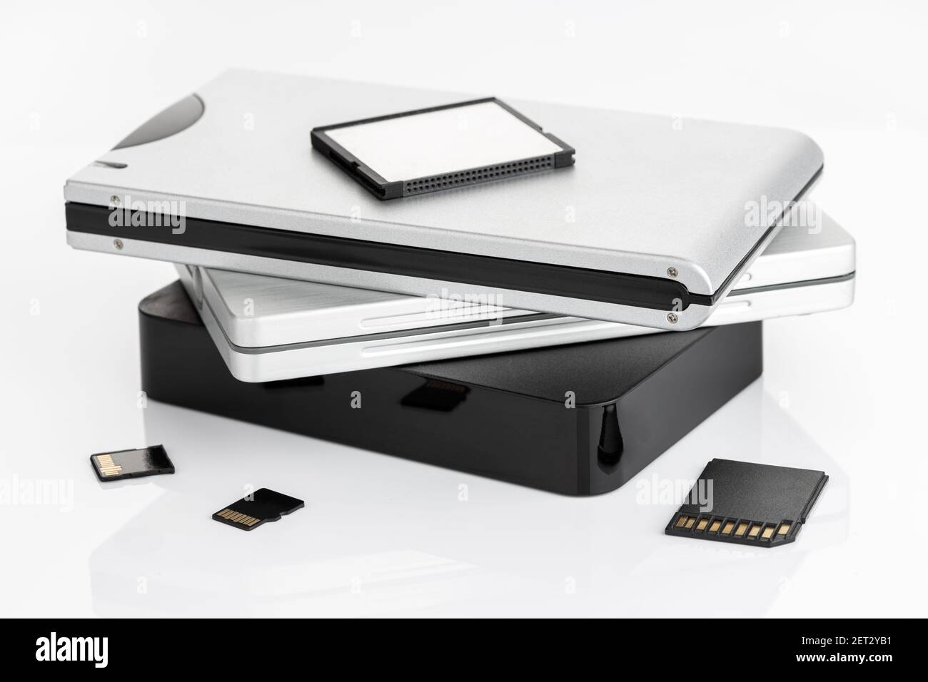 Group of external Hard disks and memory cards on white table. Data