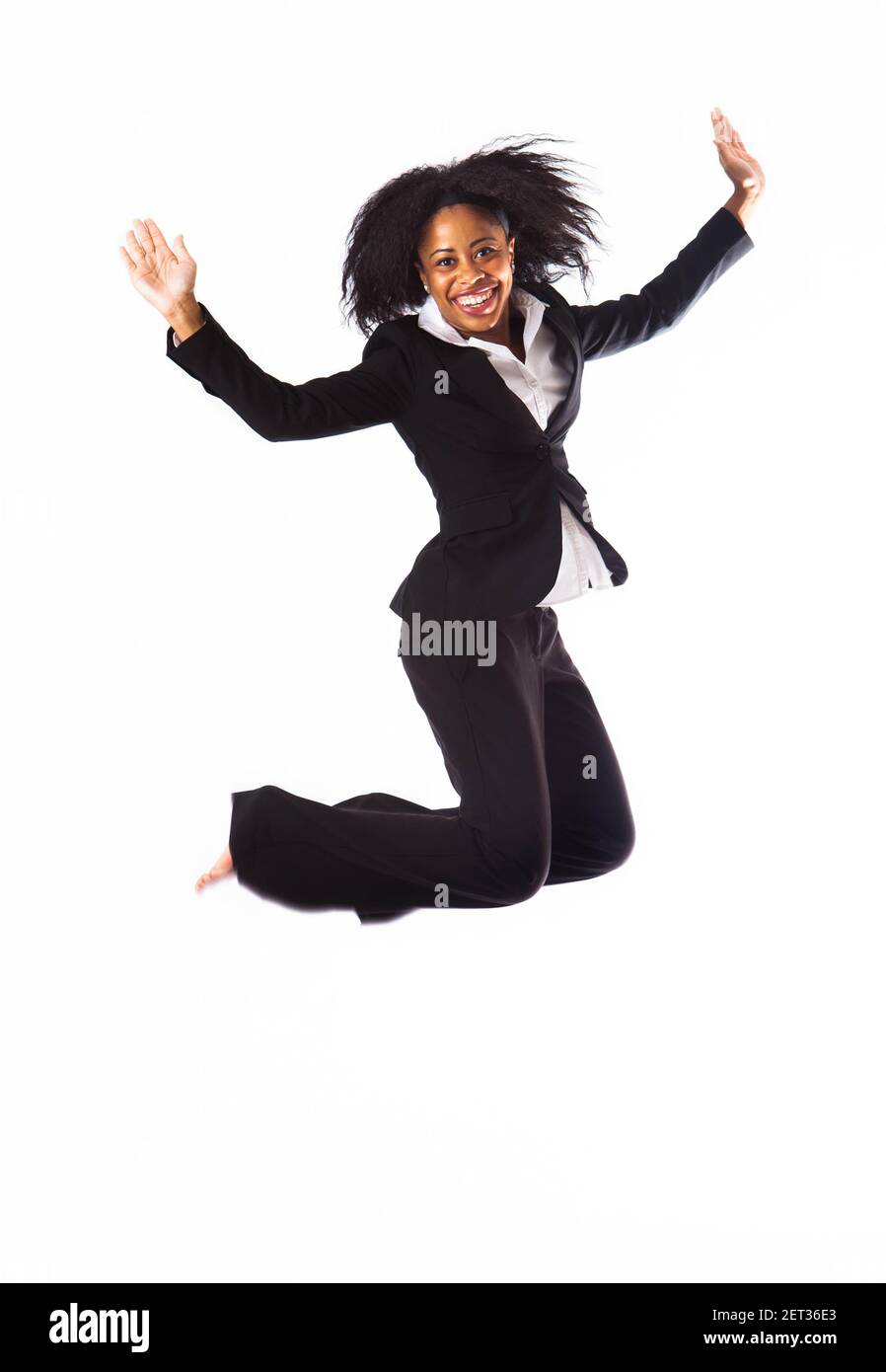 A woman in business attire jumping into the air. Isolated on a white background. Stock Photo