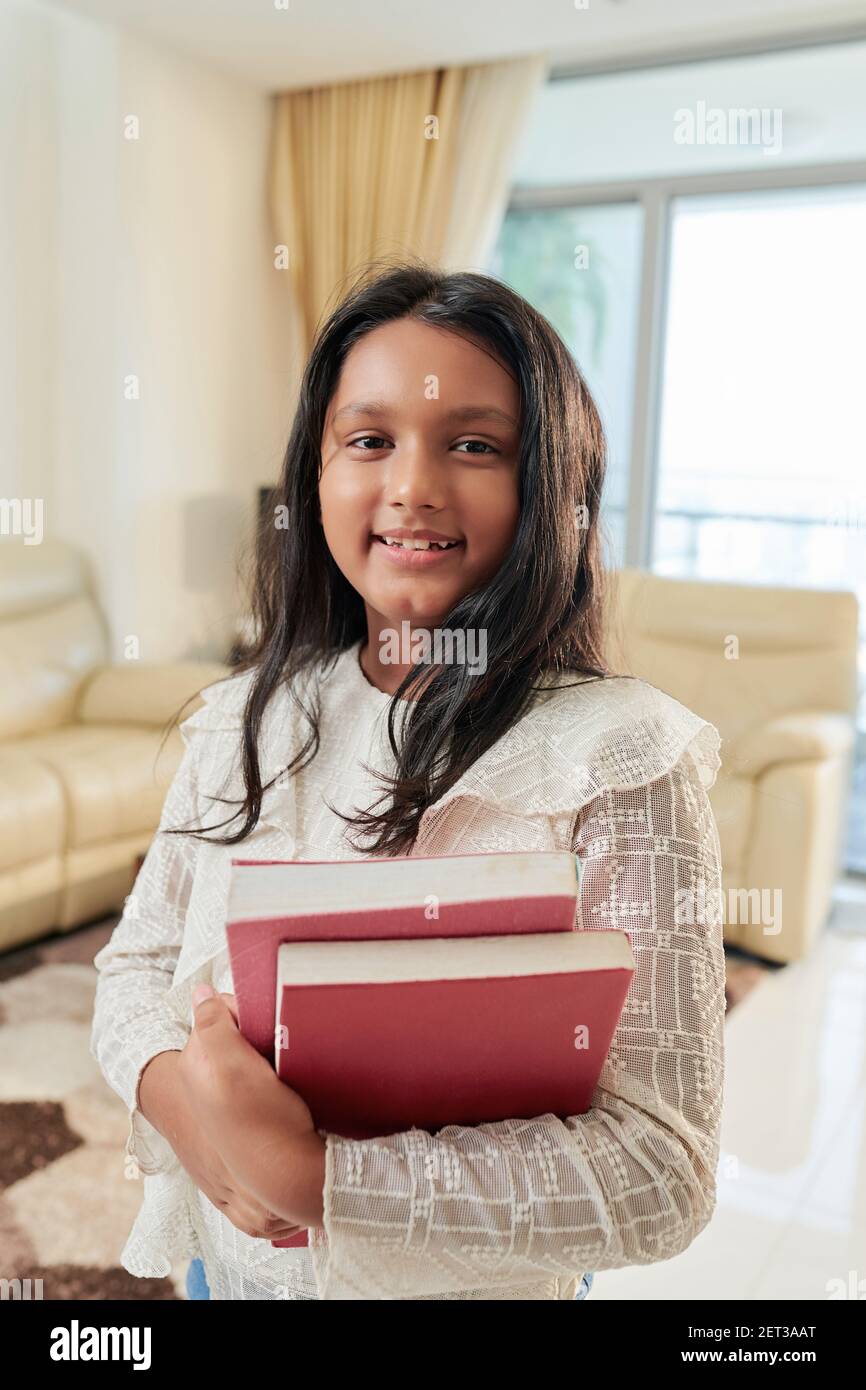 Teenage girl holding books Stock Photo - Alamy