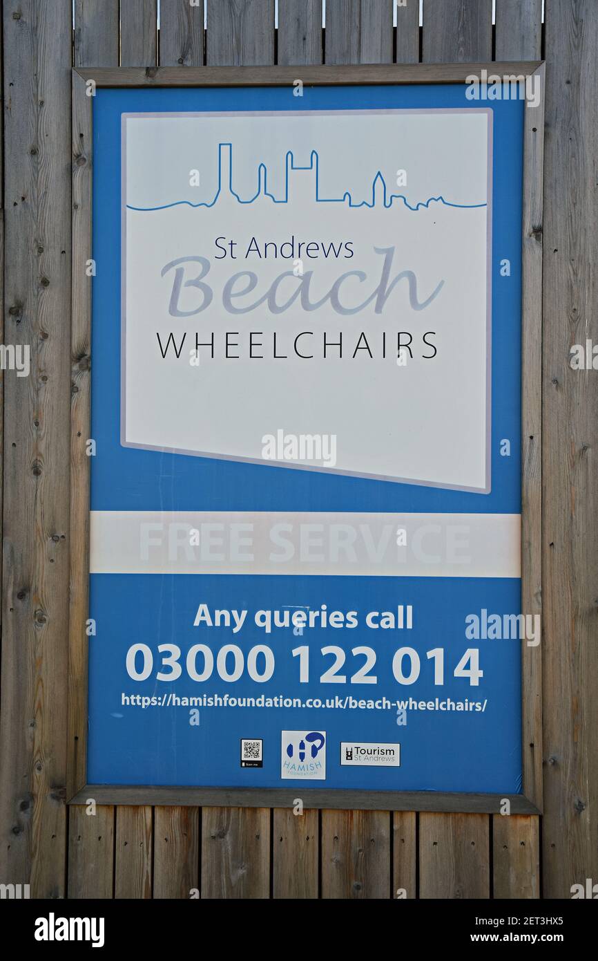 Isolated sign for St Andrews Beach Wheelchairs, a free service providing beach friendly wheelchairs on West Sands Beach Stock Photo