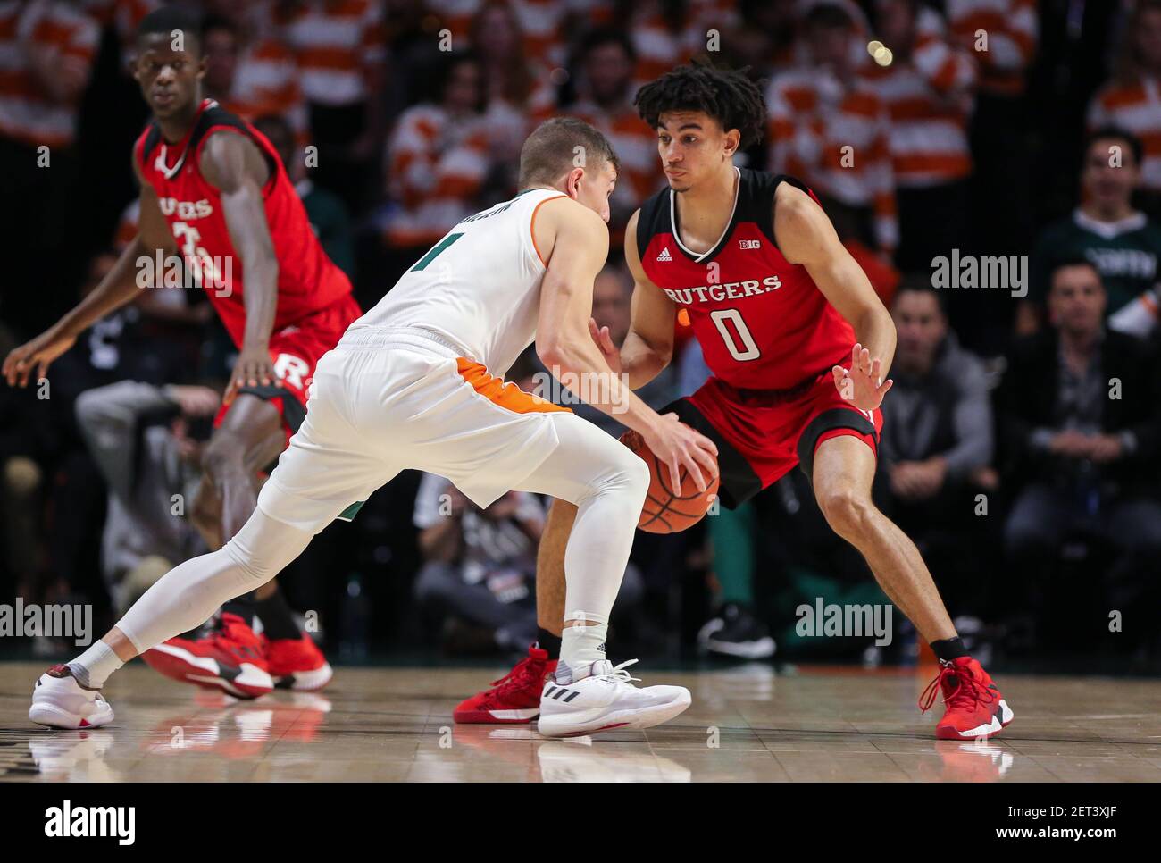 November 28, 2018: Miami Hurricanes guard Dejan Vasiljevic (1) moves the  ball defended by Rutgers Scarlet Knights guard Geo Baker (0) during the  NCAA men's basketball game between the Rutgers Scarlet Knights