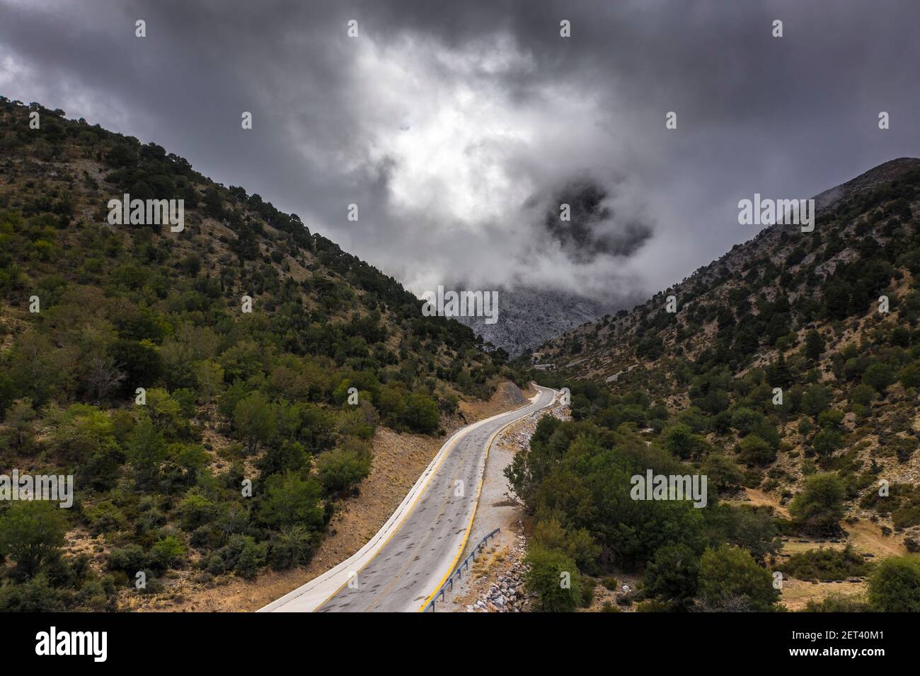 Aerial view of the road leading to the Samaria Gorge trailhead with storm clouds overhead, Crete, Greece Stock Photo