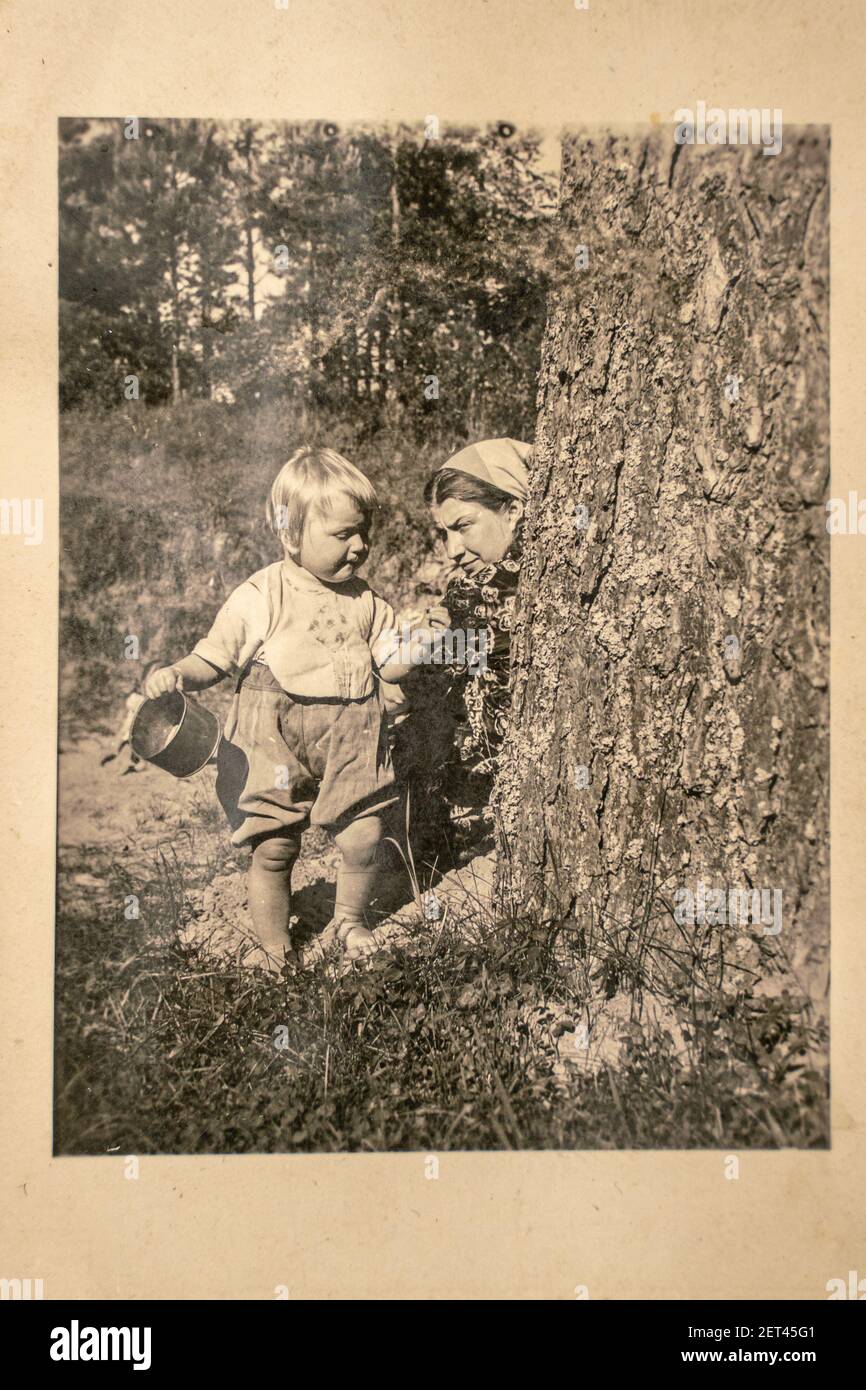 Germany - CIRCA 1930s: Mother and small kid sitting in forest. Vintage archive Art Deco era photography Stock Photo