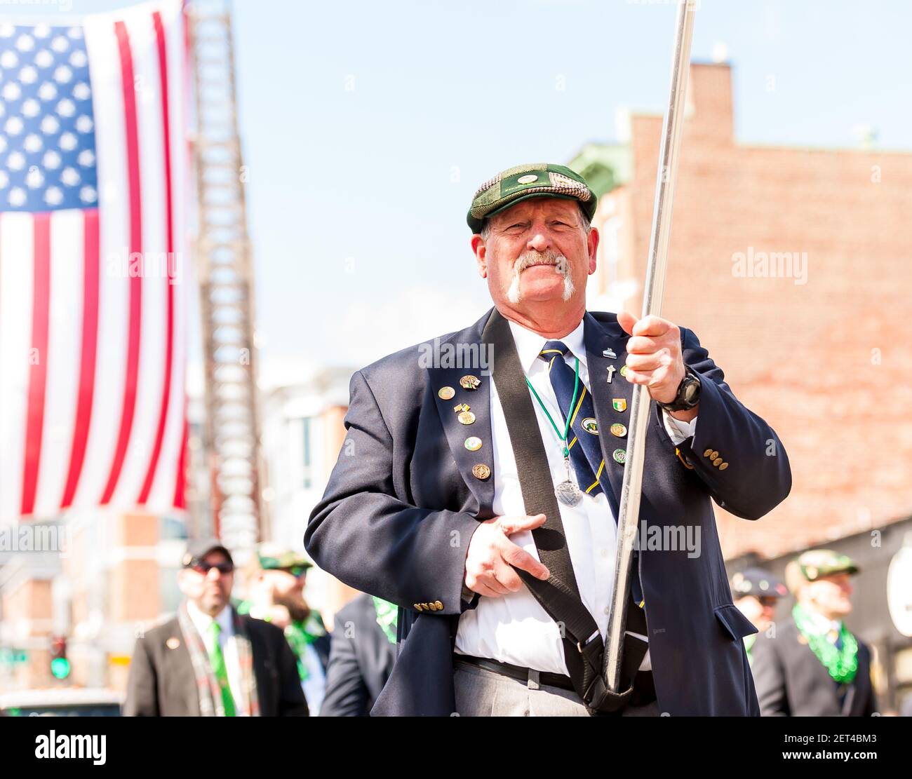 Older man with a handlebar mustache marching in the 2019 South Boston