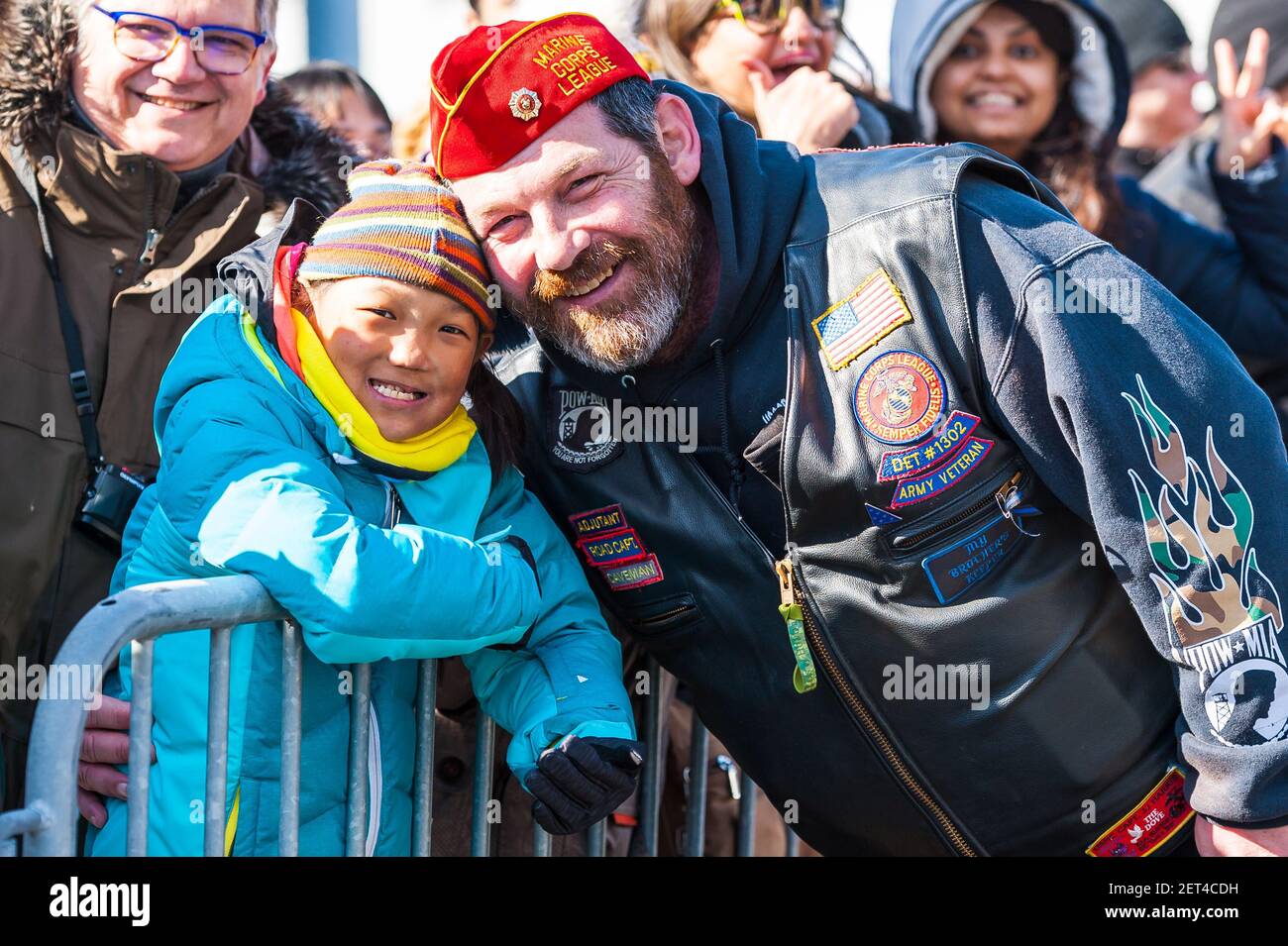 Marine veteran posing with a young boy in the audience at the 2019 South Boston Saint Patrick's Day Parade. Stock Photo