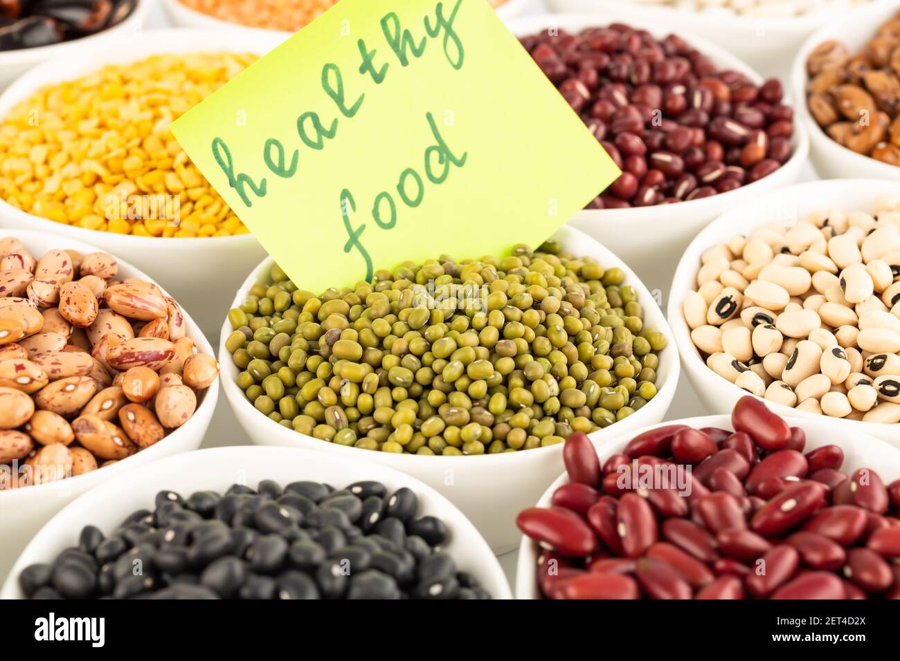 The collection of different beans and peas in the ceramic bowls with notice healthy food Stock
