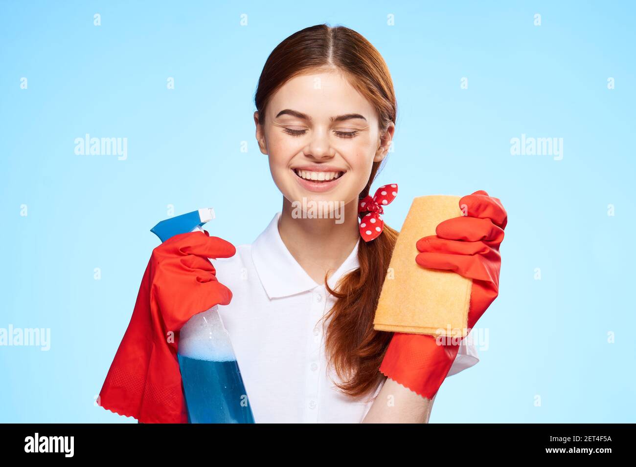 cleaning lady in white shirt cleaning supplies service blue background Stock Photo Alamy