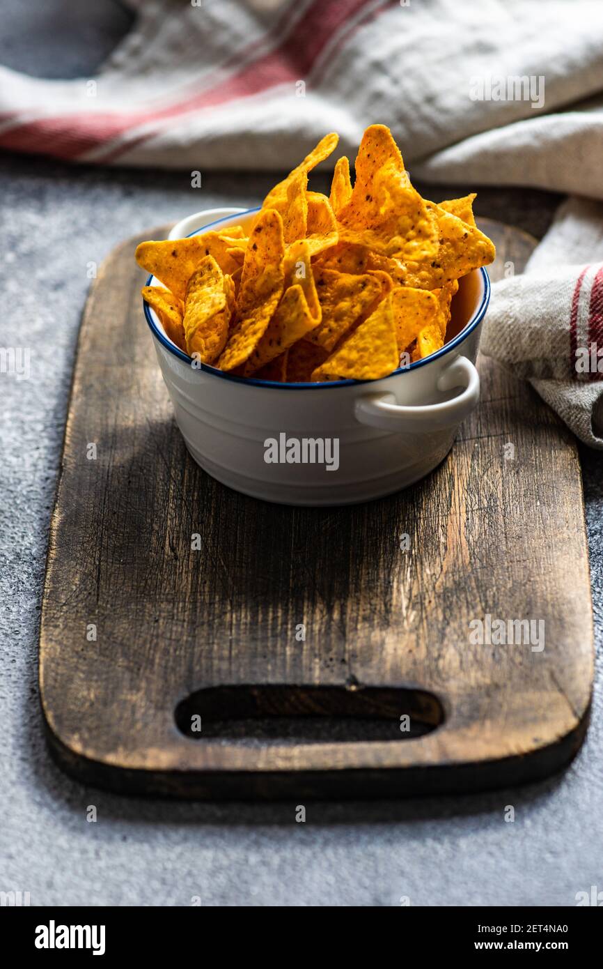 Mexican tortilla chips in a bowl on a chopping board Stock Photo