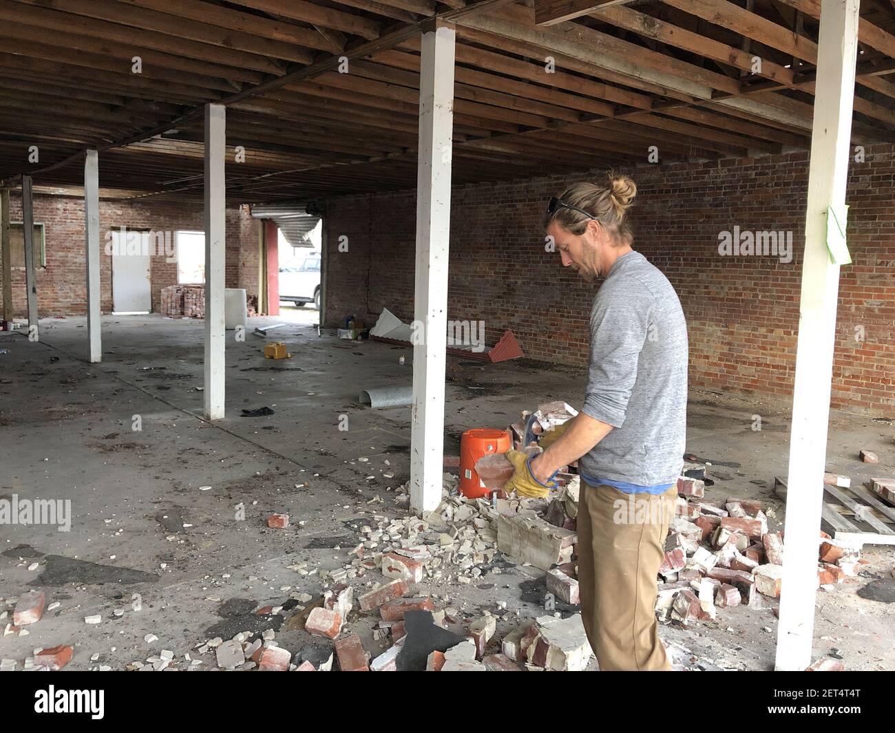Michael Nordness, 33, works to salvage bricks from the street in front