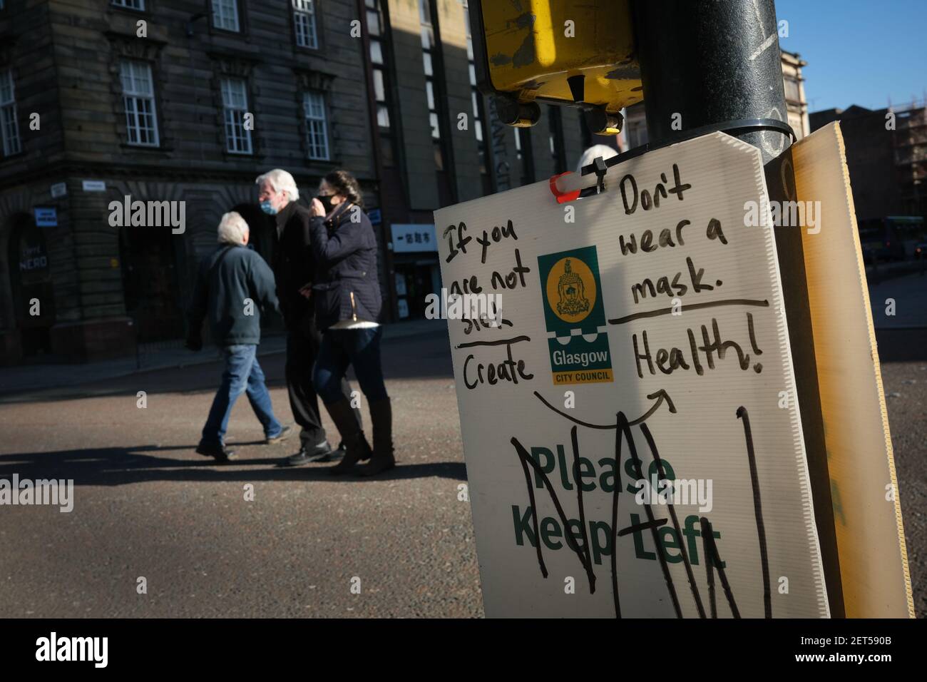 Glasgow, UK, on 1 March 2021. A safety sign with anti-mask graffiti, in the quiet city centre streets, during the latest lockdown. Over 1.5 million people have now had their first Covid-19 CoronaVirus vaccination in Scotland. Photo credit: Jeremy Sutton-Hibbert/Alamy Live News. Stock Photo