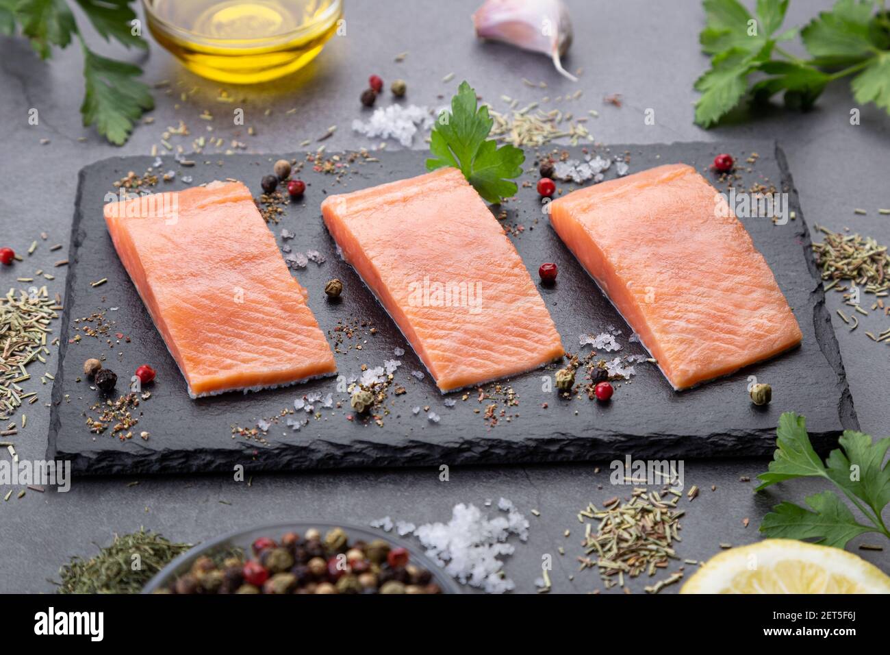 Three raw salmon filet on dark slate on dark background Stock Photo - Alamy
