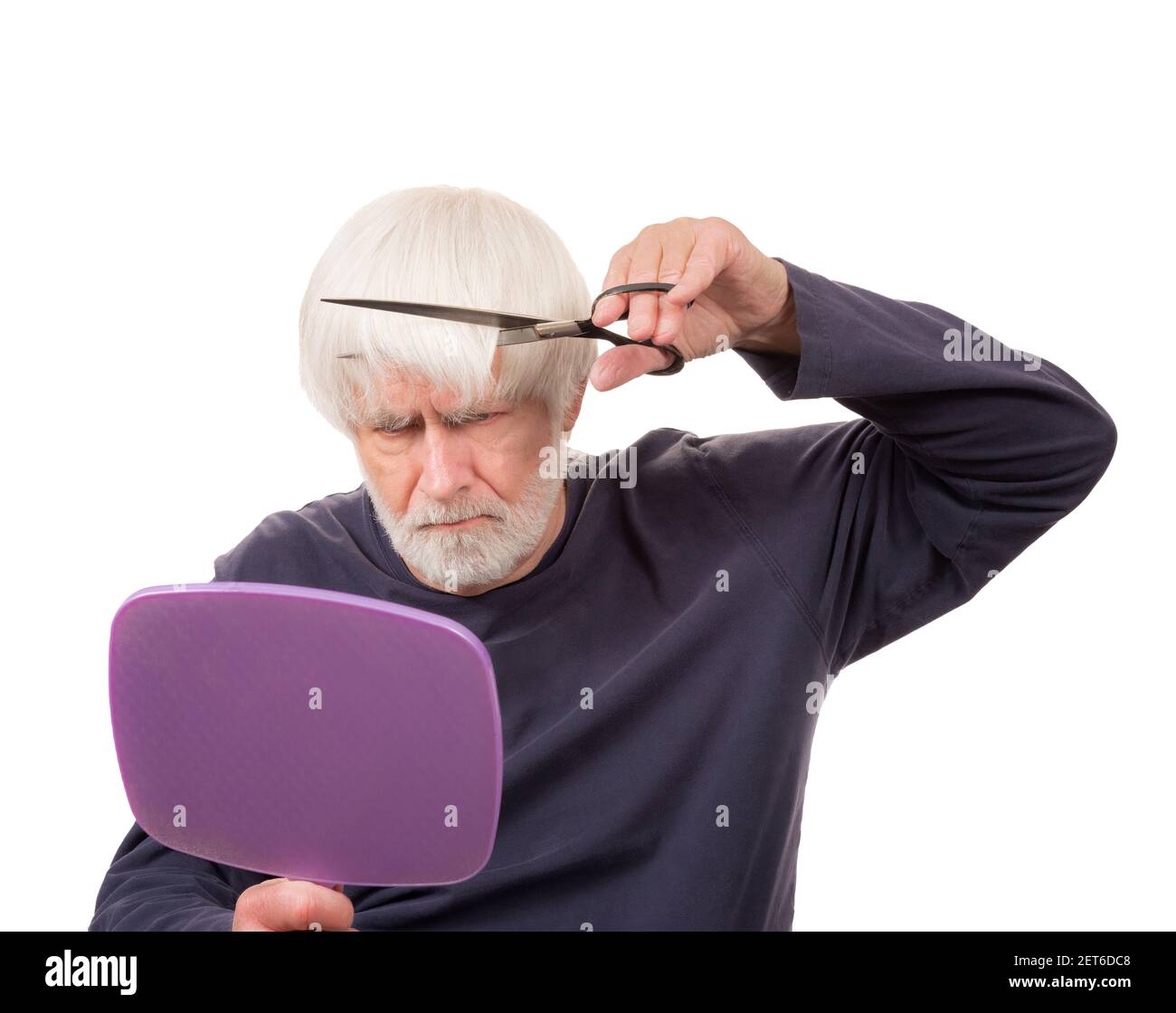 Horizontal shot of an old man giving himself a haircut during the pandemic.  White background. Stock Photo