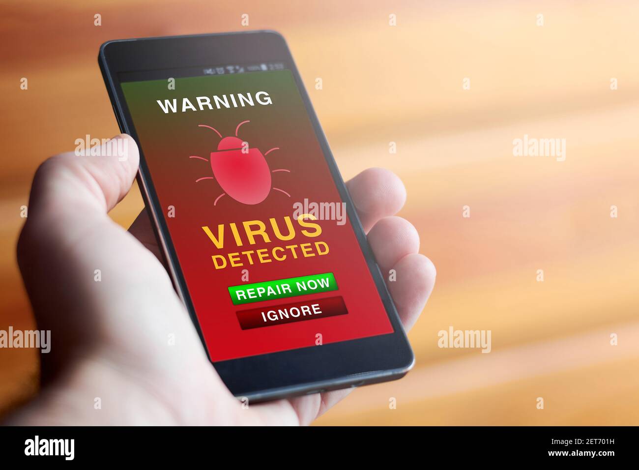 Closeup of male hand holding modern mobile phone with red antivirus warning screen showing text 'WARNING: VIRUS DETECTED'. Concept of online security. Stock Photo