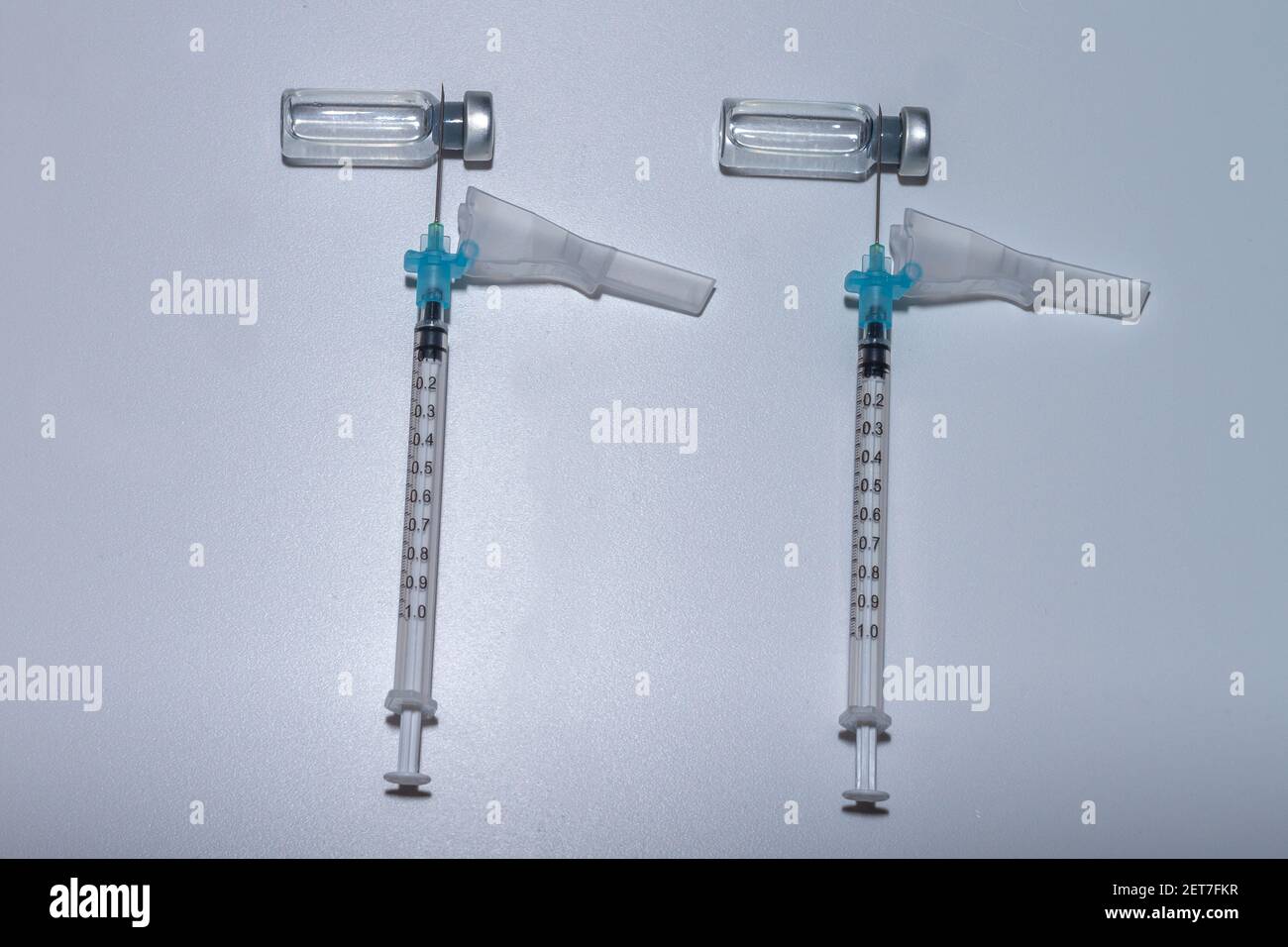 Two dose vaccination concept. Two syringes on two vials of vaccine against Covid-19 (SARS-COV2), representing that most vaccines must be Stock Photo