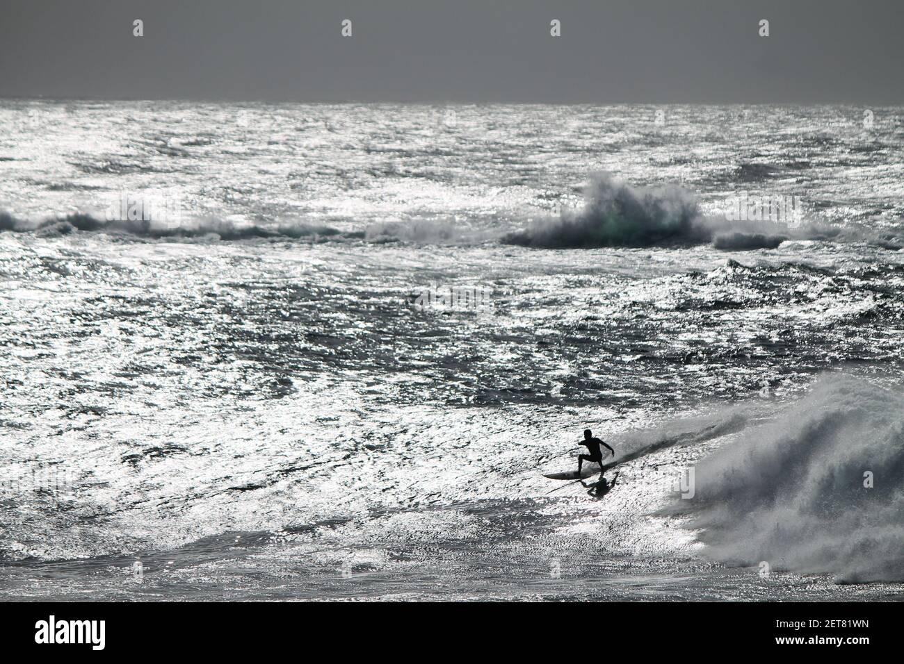 Surfer surfing a giant and sparkling wave in Coogee Australia Stock Photo