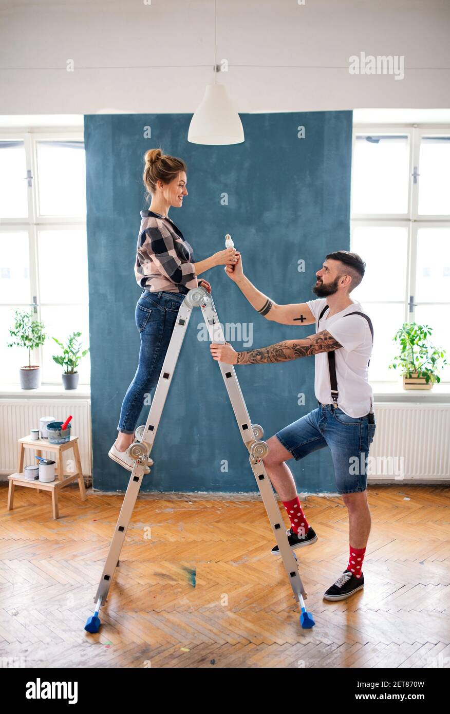 Mid adults couple painting indoors at home, relocation and diy concept. Stock Photo