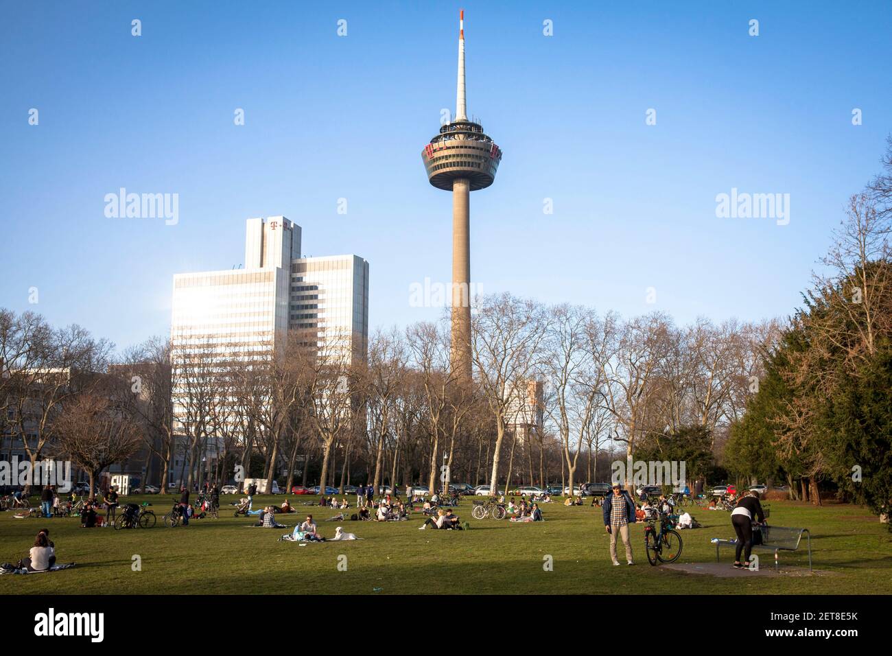 people enjoying an exceptionally warm day on February 24th. 2021 in the park Innerer Gruenguertel, Colonius television tower, Cologne, Germany.  Mensc Stock Photo