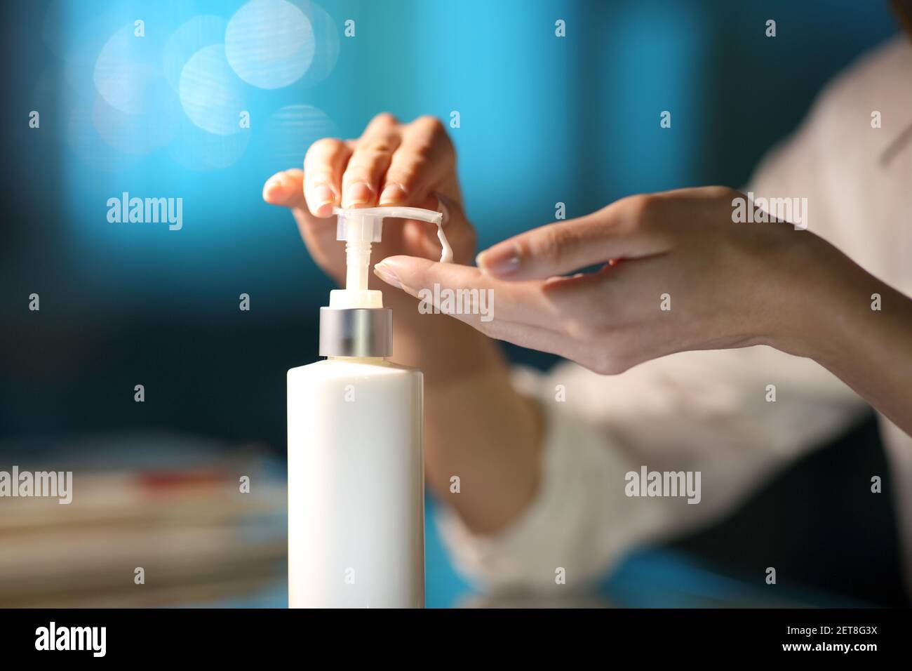 Close up of a woman hands applying moisturizer cream in the night at home Stock Photo